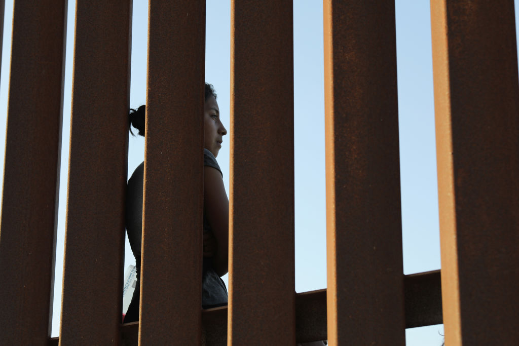 MISSION, TX - JUNE 12: A Central American immigrant stands at the U.S.-Mexico border fence after crossing into Texas on June 12, 2018 near Mission, Texas. U.S. Customs and Border Protection (CBP) is executing the Trump administration's zero tolerance policy towards undocumented immigrants. U.S. Attorney General Jeff Sessions also said that domestic and gang violence in immigrants' country of origin would no longer qualify them for political-asylum status. (Photo by John Moore/Getty Images)