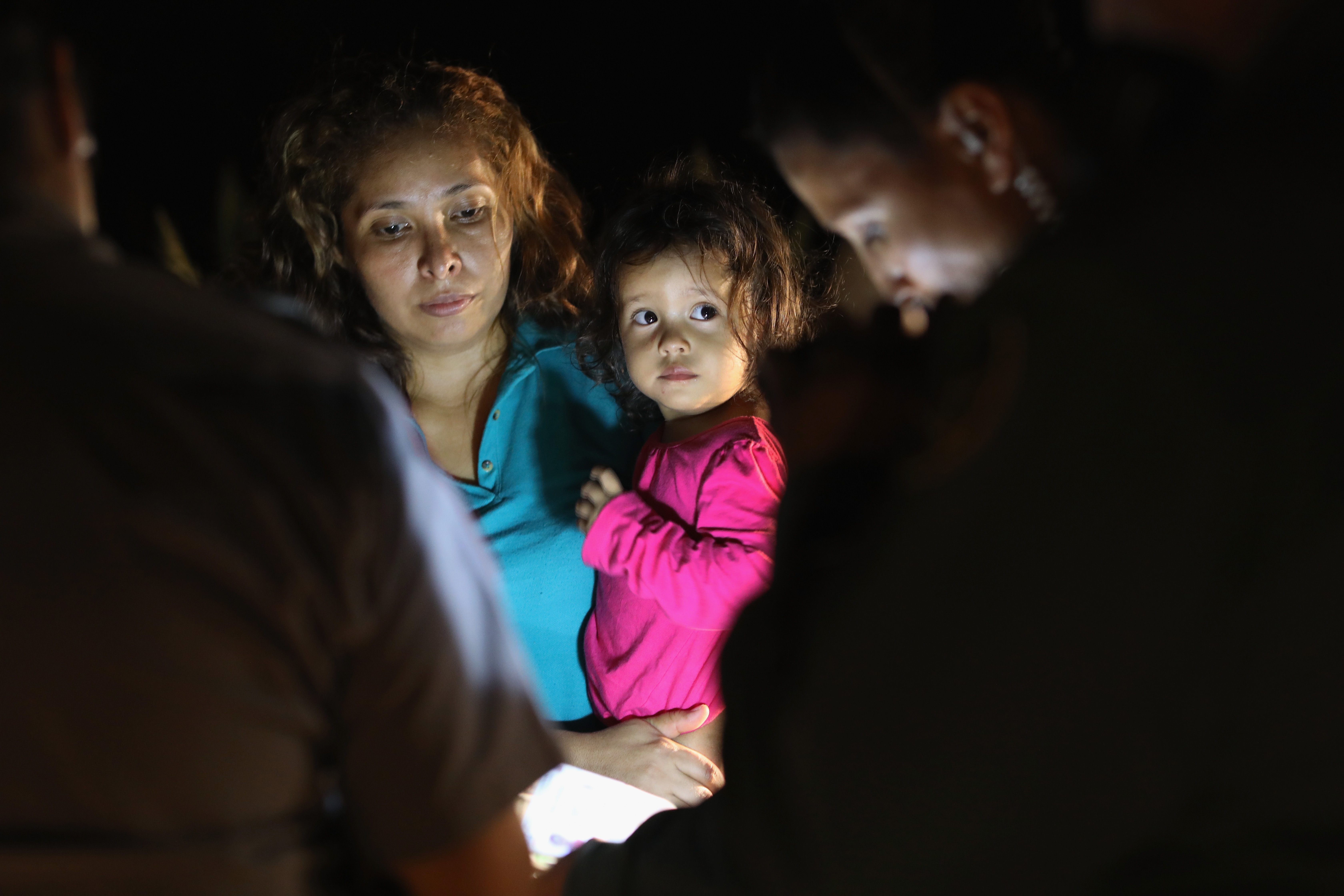 Central American asylum seekers, including a Honduran girl, 2, and her mother, are taken into custody near the U.S.-Mexico border on June 12, 2018 in McAllen, Texas. The group of women and children had rafted across the Rio Grande from Mexico and were detained by U.S. Border Patrol agents before being sent to a processing center for possible separation. (CREDIT: John Moore/Getty Images)