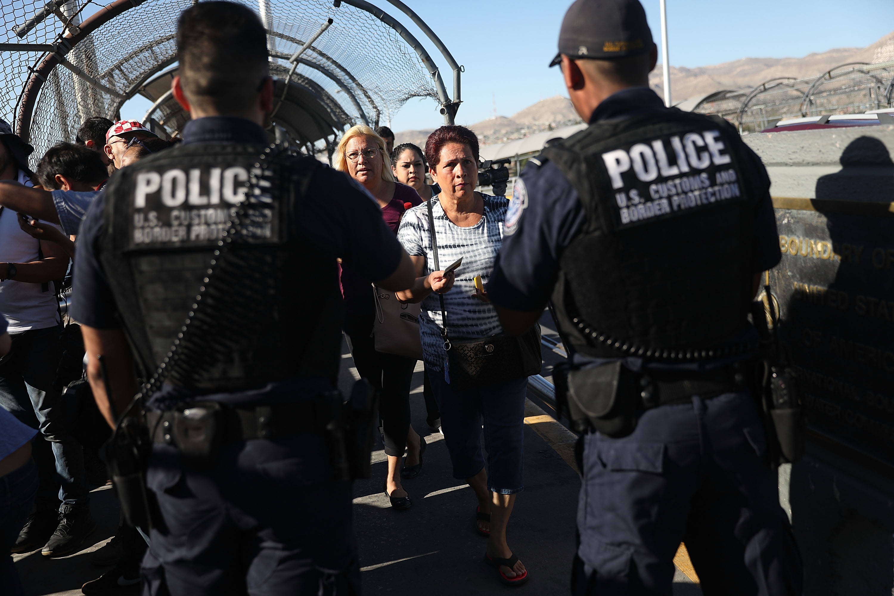 U.S. Border Patrol agents check passports at the Paso Del Norte Port of Entry, where the U.S. and Mexico border meet, as people walk across the bridge to enter the United States on June 20, 2018 in El Paso, Texas. CREDIT: Joe Raedle/Getty Images