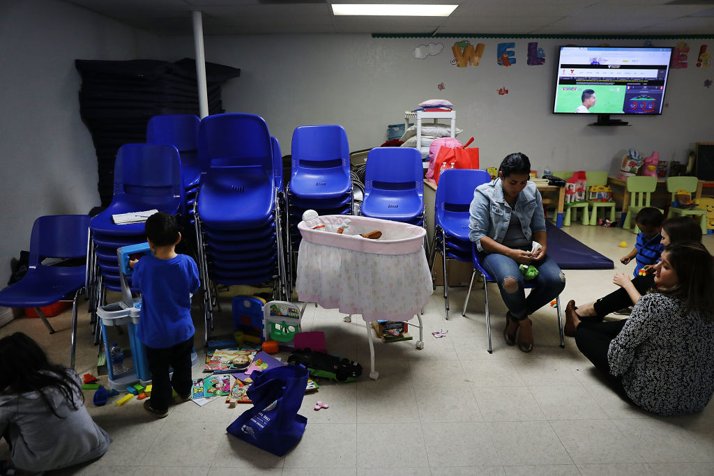 Recently arrived migrant families speak with volunteers at the Catholic Charities Humanitarian Respite Center on June 21, 2018 in McAllen, Texas. CREDIT: Spencer Platt/Getty Images