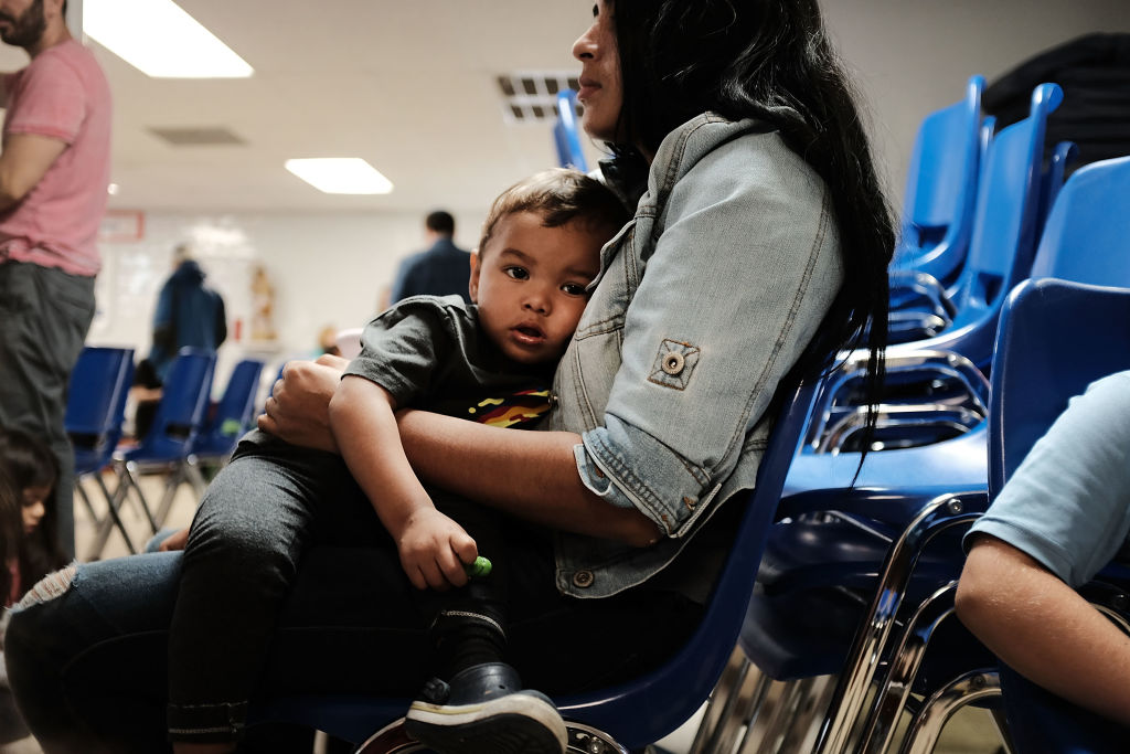 A woman who identified herself as Jennifer sits with her son Jaydan at the Catholic Charities Humanitarian Respite Center after recently crossing the U.S., Mexico border on June 21, 2018 in McAllen, Texas. (CREDIT: Spencer Platt/Getty Images)