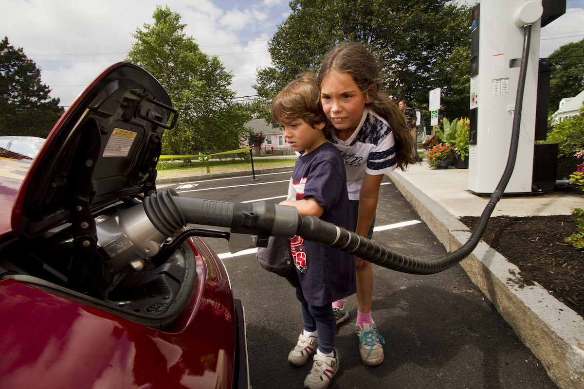 Kids look at an electric car charging in South Portland, Maine, July 2014. CREDIT: Carl D. Walsh/Portland Press Herald via Getty Images