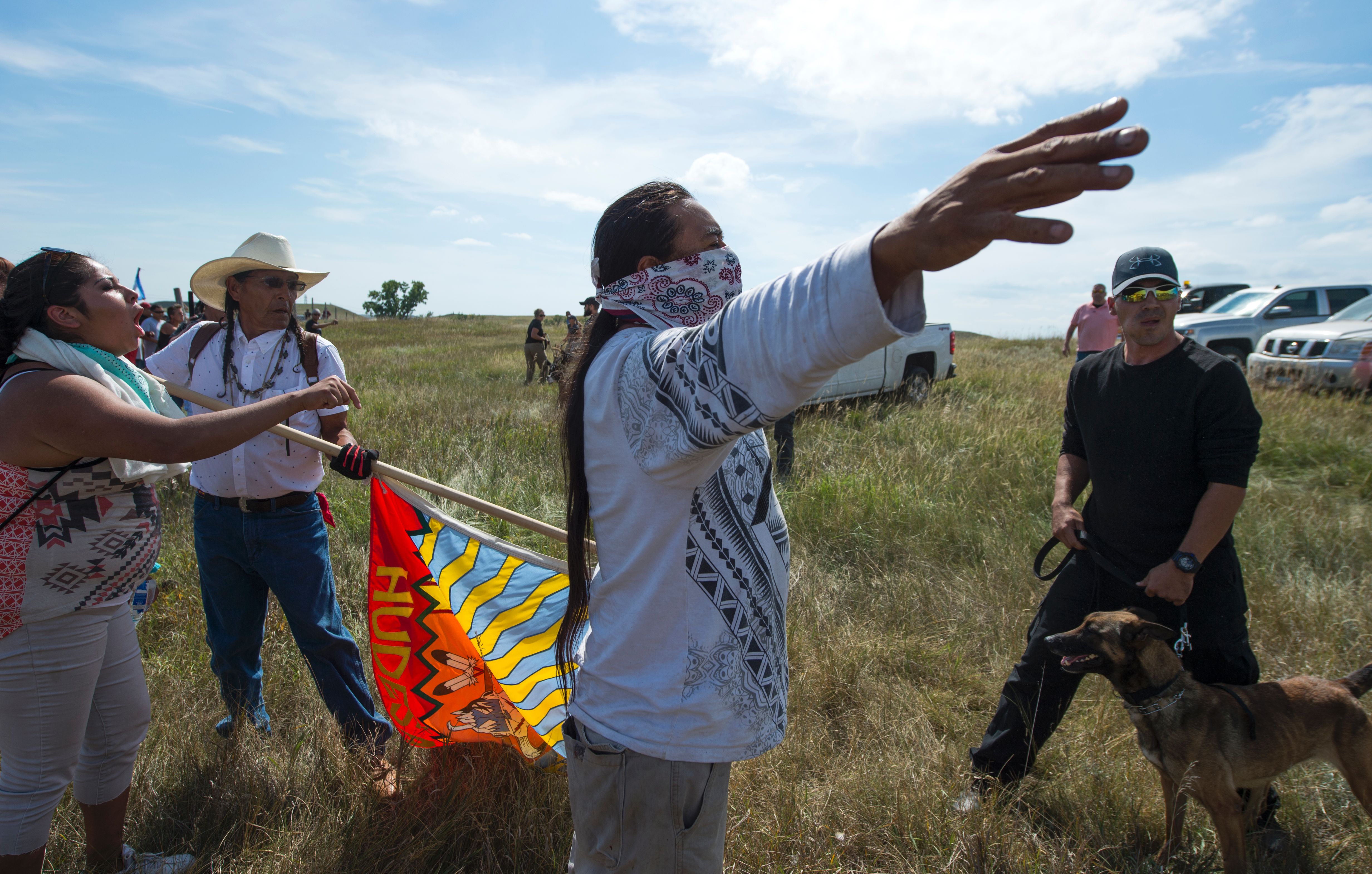 A Native American protester holds up his arms as he and other protesters are threatened by private security guards and guard dogs, at a work site for the Dakota Access Pipeline in North Dakota on September 3, 2016. CREDIT: ROBYN BECK/AFP/Getty Images