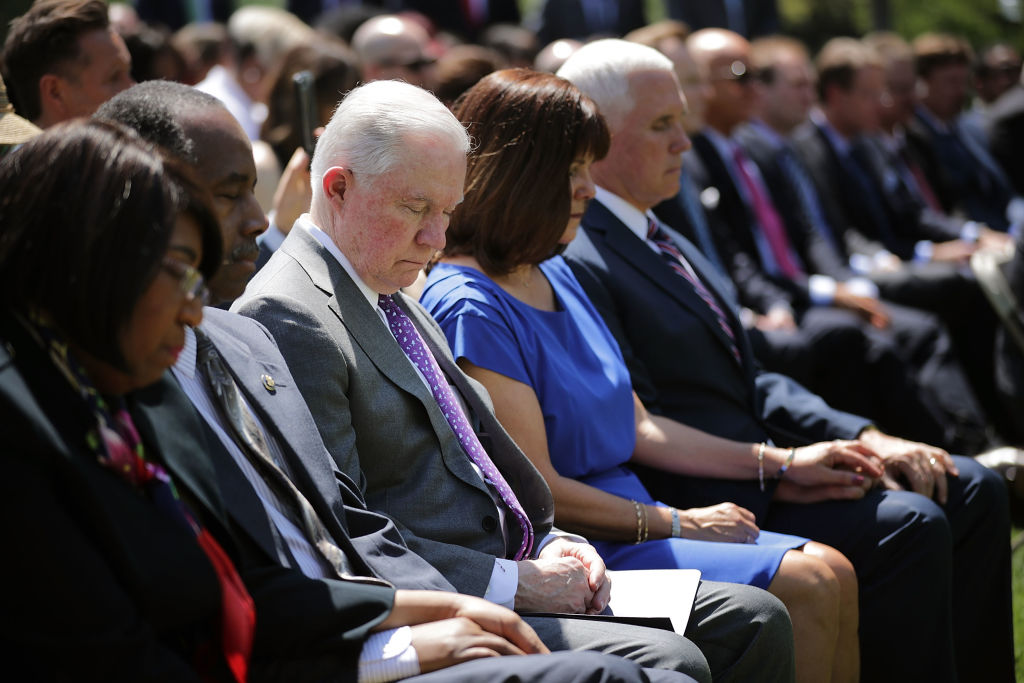 U.S. Attorney General Jeff Sessions (C) and fellow members of President Donald Trump's cabinet bow their heads in prayer during an event to mark the National Day of Prayer in the Rose Garden at the White House May 3, 2018 in Washington, DC. (Credit: Chip Somodevilla/Getty Images)