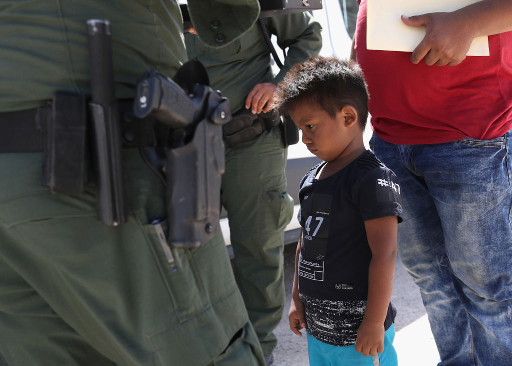 A boy and father from Honduras are taken into custody by U.S. Border Patrol agents near the U.S.-Mexico Border on June 12, 2018 near Mission, Texas. The asylum seekers were then sent to a U.S. Customs and Border Protection (CBP) processing center for possible separation. (Credit: John Moore/Getty Images)