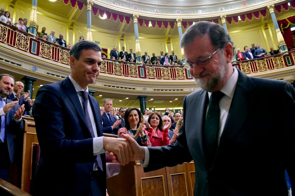 Spain's new Prime Minister Pedro Sanchez (L) shakes hands with Spain's out-going Prime Minister Mariano Rajoy (R) after a vote on a no-confidence motion at the Lower House of the Spanish Parliament in Madrid on June 01, 2018. (Photo by PIERRE-PHILIPPE MARCOU / POOL / AFP)