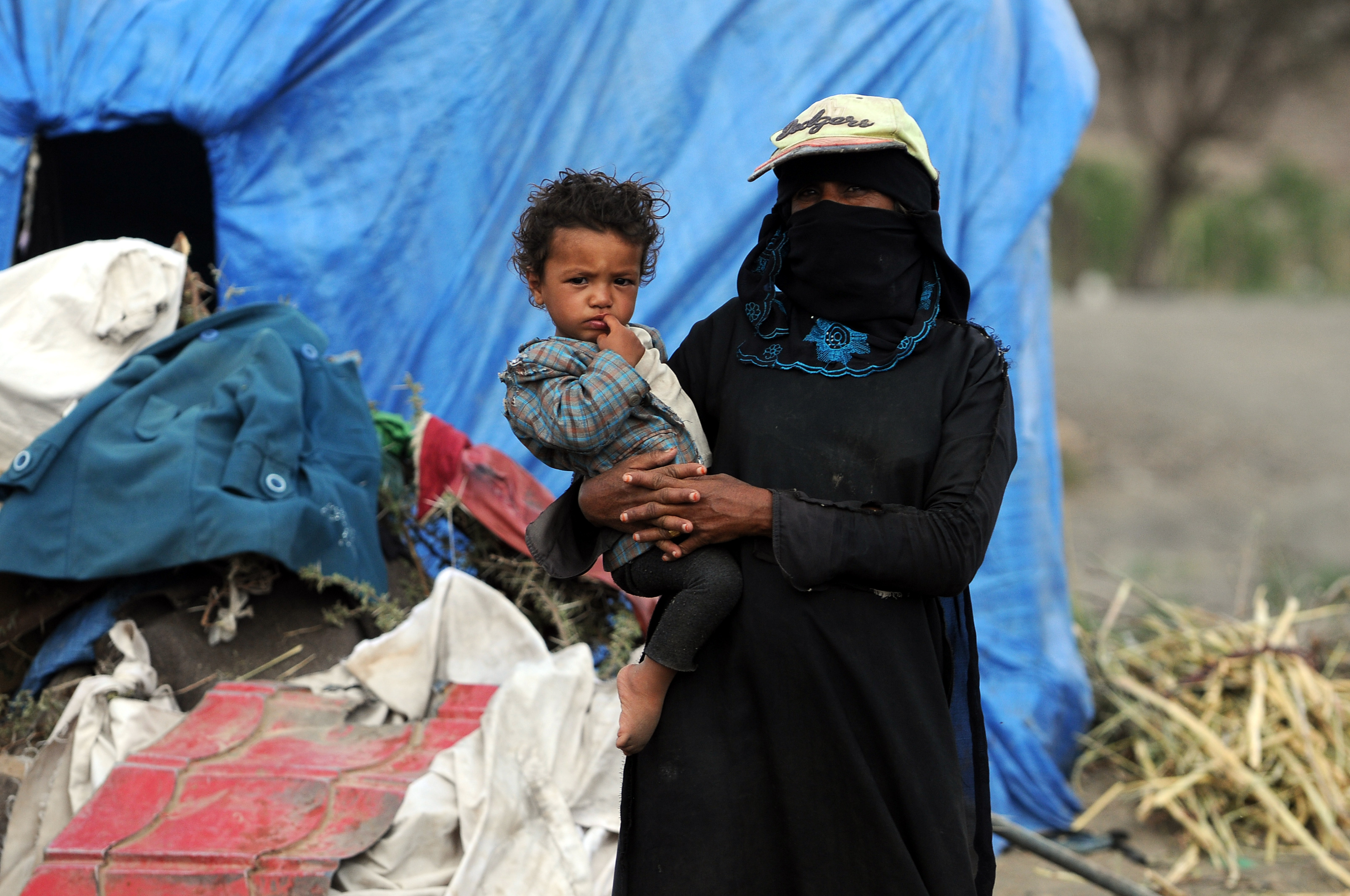 A Yemeni internally displaced woman holds her child at a displaced persons camp on May 30, 2018 near Sana’a, Yemen. According to the U.N.'s refugee agency, conflict in Yemen has left 22.2 million people, 75 per cent of the population, in need of humanitarian assistance. CREDIT: Mohammed Hamoud/Getty Images.