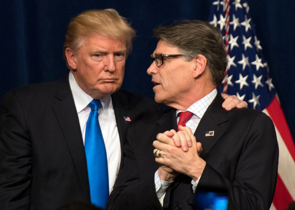 President Donald Trump embraces Energy Secretary Rick Perry June 29, 2017 in Washington, DC. On Friday, Trump called on Perry to bailout money-losing coal plants by raising U.S. electricity rates: CREDIT: Kevin Dietsch-Pool/Getty Images