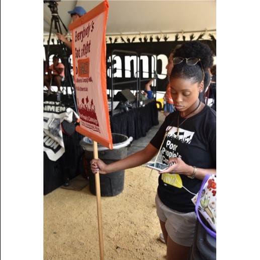 A Poor People’s Campaign worker checks her phone for messages during Monday’s kickoff rally on the National Mall in Washington, D.C. (Think Progress Photo – Sam Fulwood III)