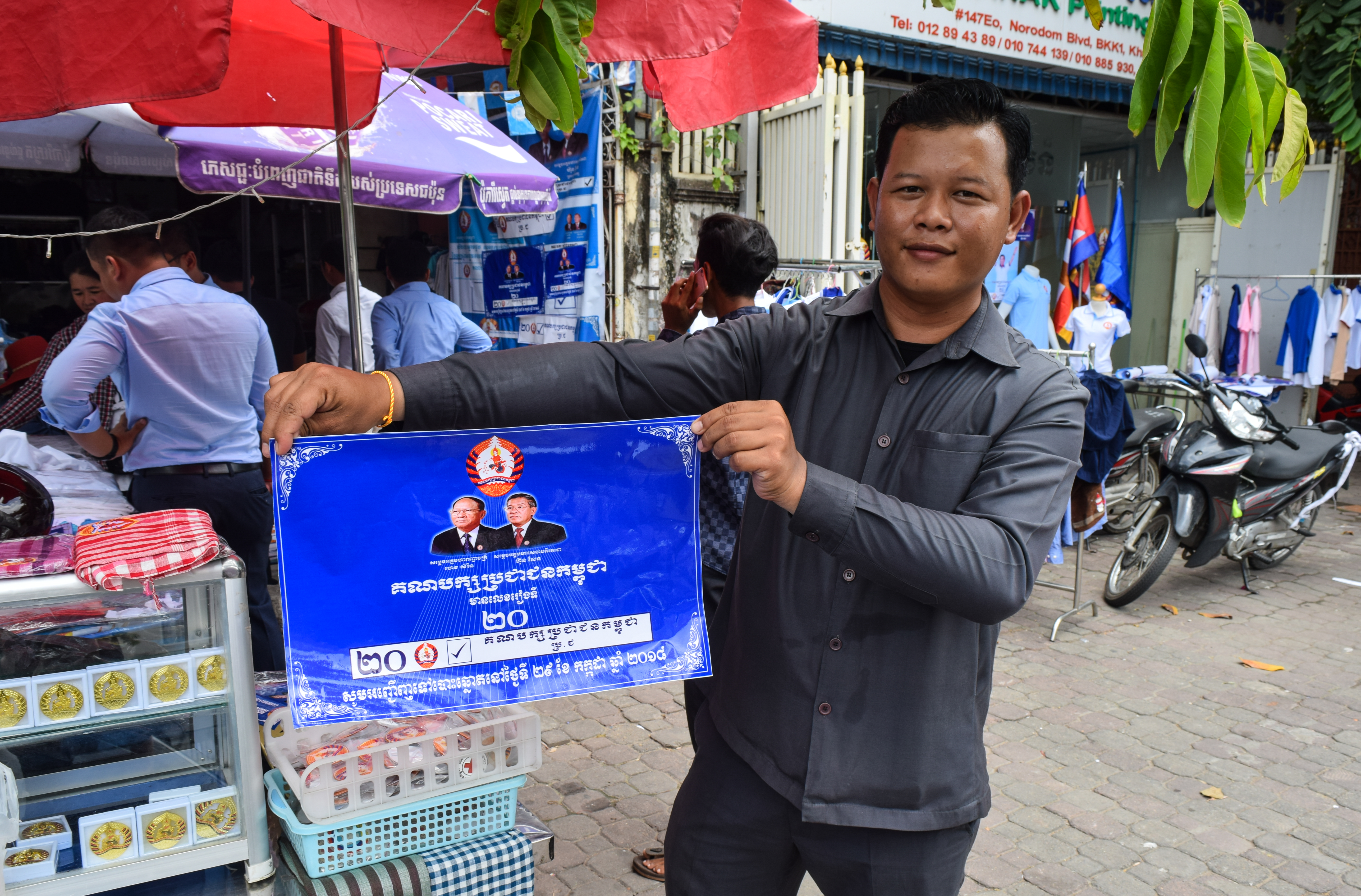 A man holds a sign touting Hun Sen's CPP. (Credit: Peter Ford for ThinkProgress)