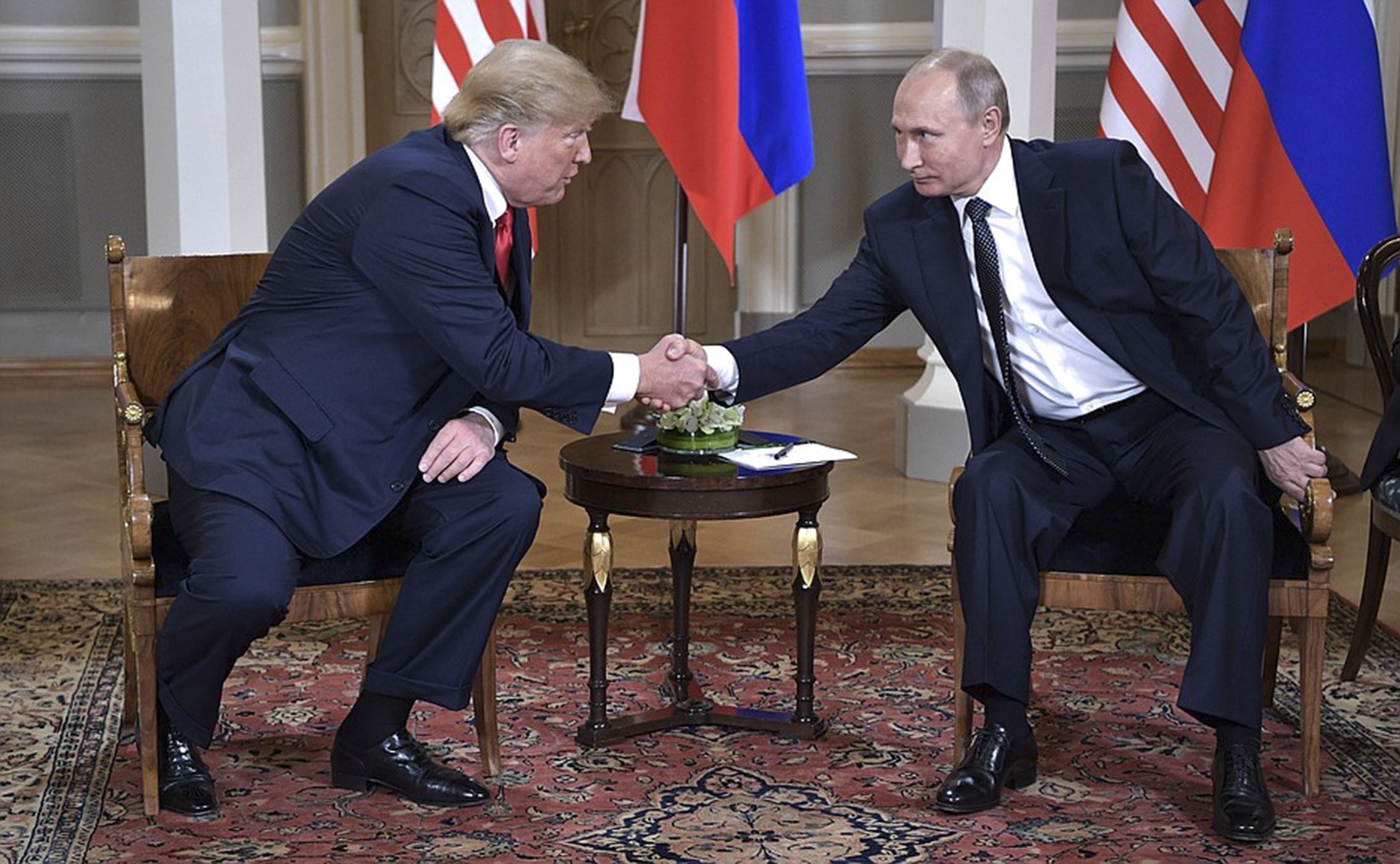 HELSINKI, FINLAND - JULY 16: (----EDITORIAL USE ONLY MANDATORY CREDIT - "KREMLIN PRESS OFFICE / HANDOUT" - NO MARKETING NO ADVERTISING CAMPAIGNS - DISTRIBUTED AS A SERVICE TO CLIENTS----) Russian President Vladimir Putin (R) and U.S. President Donald Trump (L) shake hands ahead of their bilateral summit in Helsinki, Finland on July 16, 2018. (Photo by Kremlin Press Office / Handout/Anadolu Agency/Getty Images)