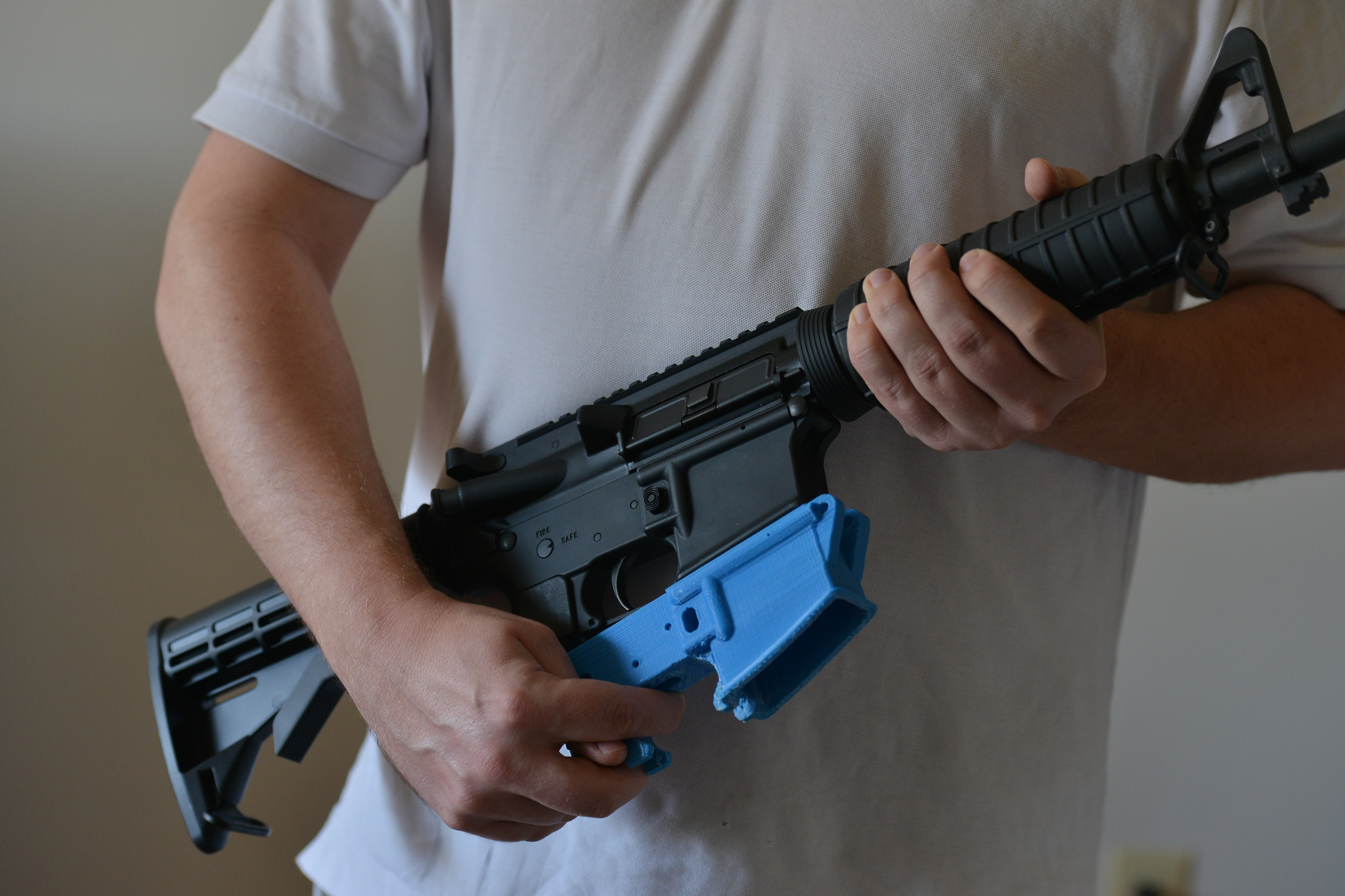 Travis Lerol holds an AR-15 assault rifle along with a rifle's lower receiver made of ABS (Acrylonitrile Butadiene Styrene) plastic that was constructed by his 3D printer at his home on Tuesday, February 12, 2012, in Glen Burnie, MD.
(Photo by Jahi Chikwendiu/The Washington Post via Getty Images)