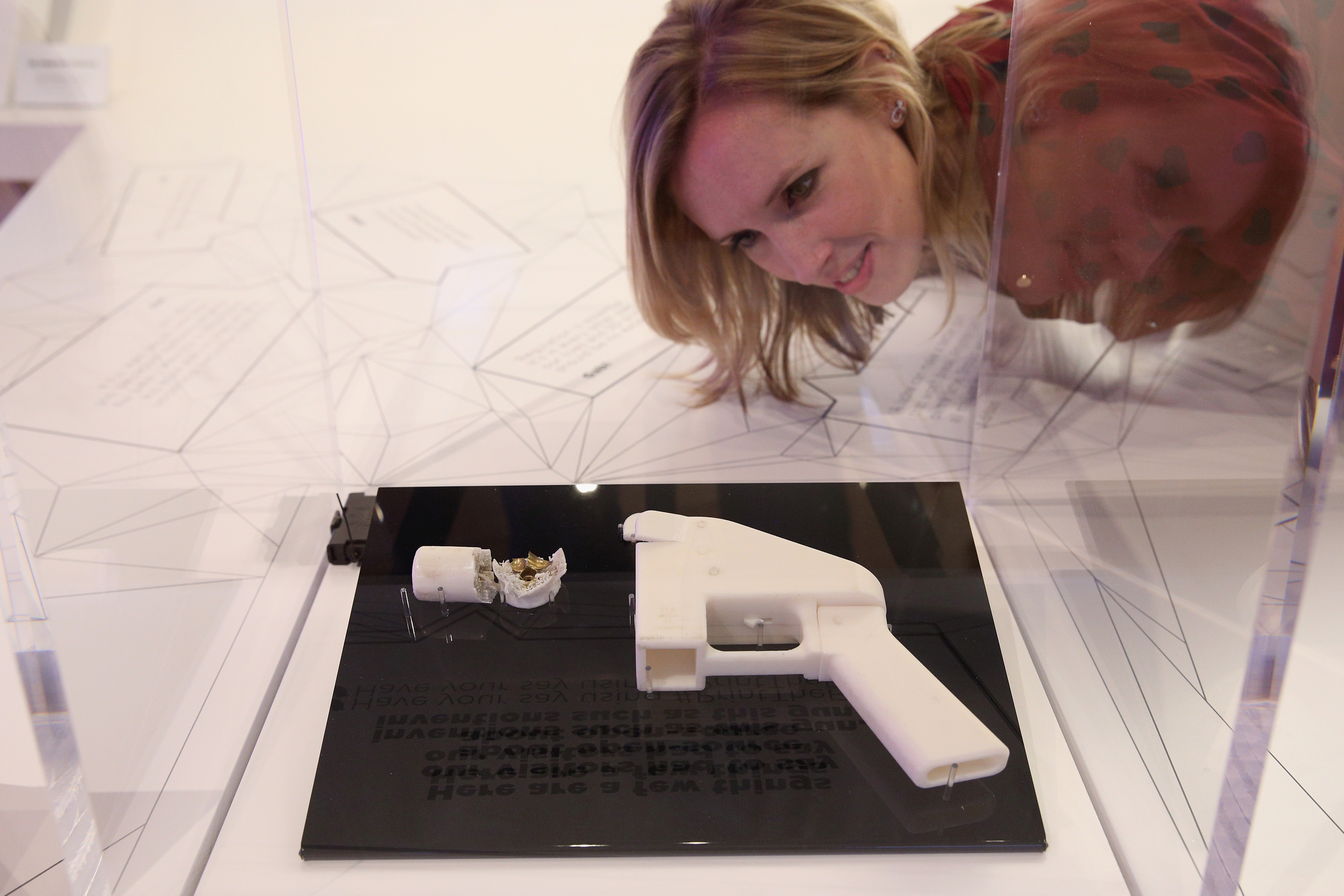 A woman admires a 3D printed handgun which was created and fired by Finnish journalist Ville Vaarne (Photo by Oli Scarff/Getty Images)