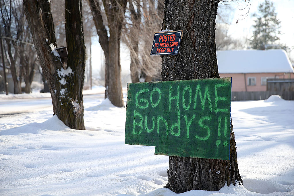 A sign posted by Burns, OR, locals asking anti-government extremists to leave the town during a January 2016 standoff. The Bundys were unwelcome gadflies during local frustration over the harsh prison sentences imposed on a pair of local ranchers. CREDIT: Justin Sullivan/Getty Images