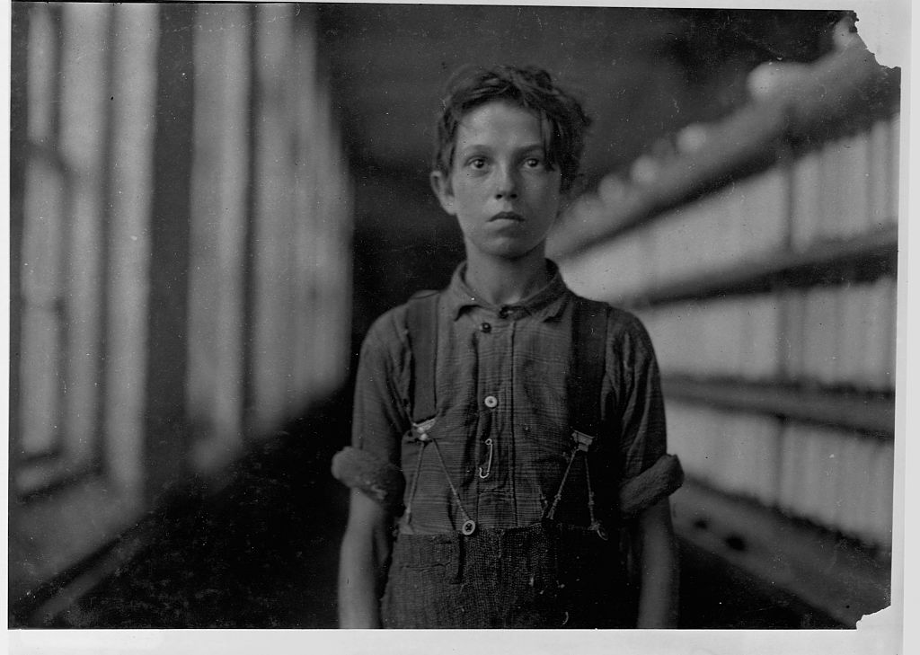 Jo Hudson, a "back-roper," stands next to a machine that dispenses thread, in the "mule room" at the Chace Cotton Mill in Burlington, Vermont. (Photo by Library of Congress/Corbis/VCG via Getty Images)
