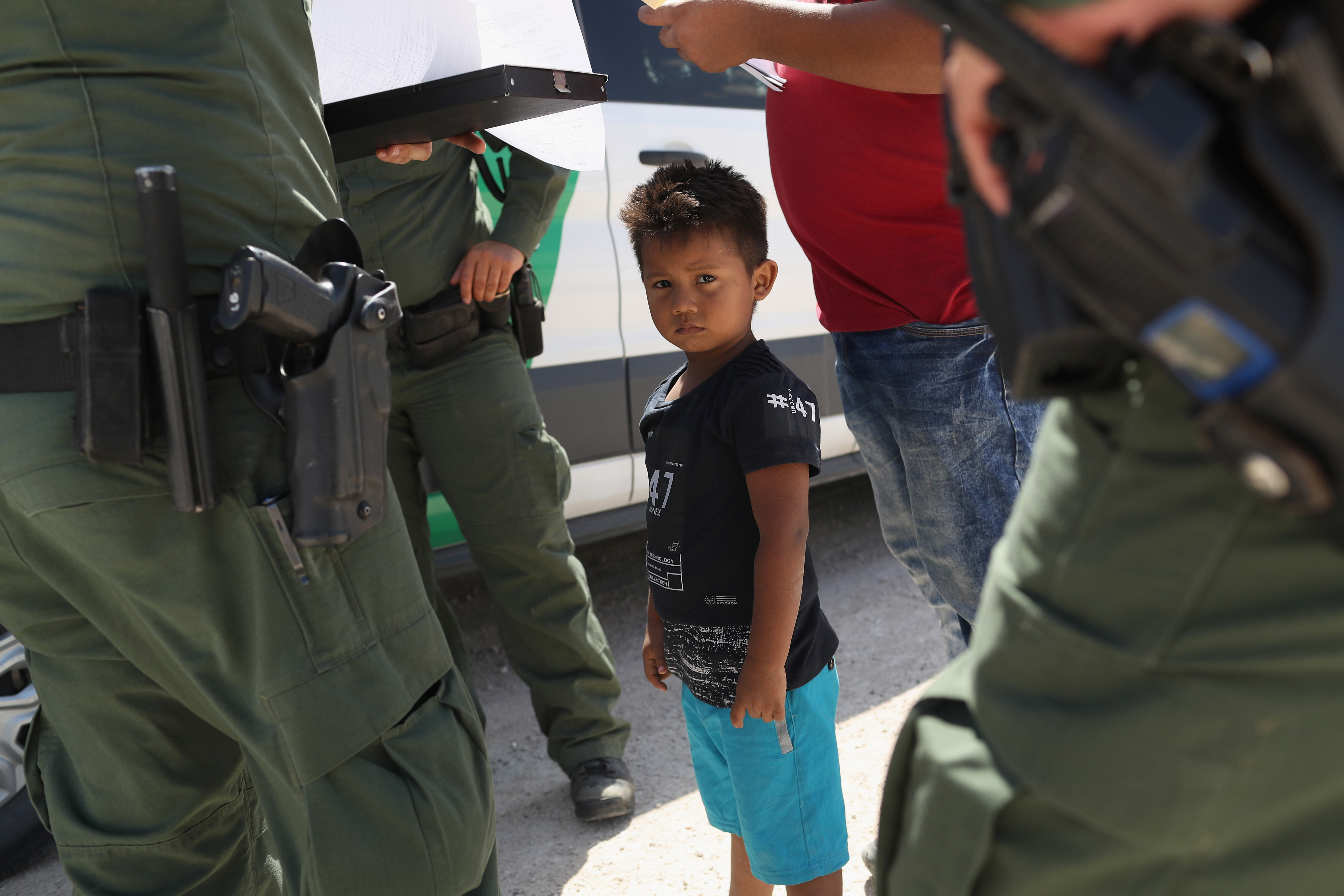 U.S. Border Patrol agents take into custody a father and son from Honduras near the U.S.-Mexico border on June 12, 2018 near Mission, Texas. (CREDIT: John Moore/Getty Images)