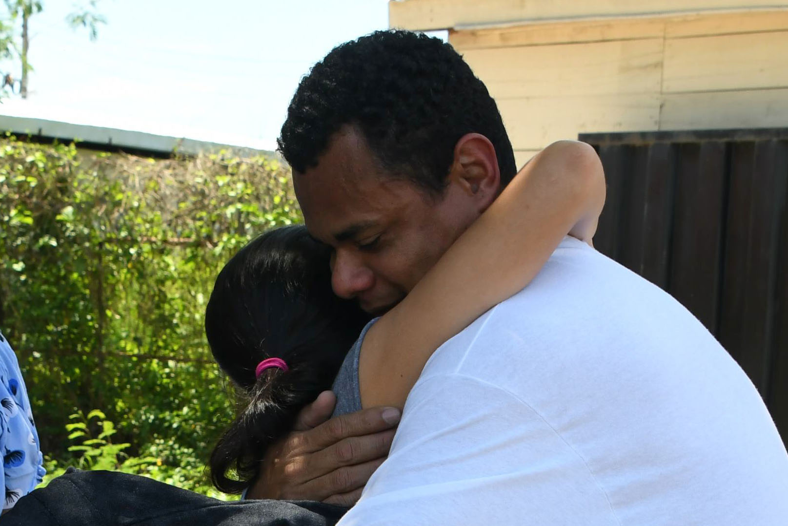 An Honduran immigrant is received by his family at the Ramon Villeda Morales airport, in San Pedro Sula, 200 kilometres north of Tegucigalpa, after being deported from the US, on June 22, 2018. - 238 Honduran citizens deported from the US arrived on Friday back to their country. According to their testimony they travelled hand, foot and waist chained. (Photo by ORLANDO SIERRA / AFP)