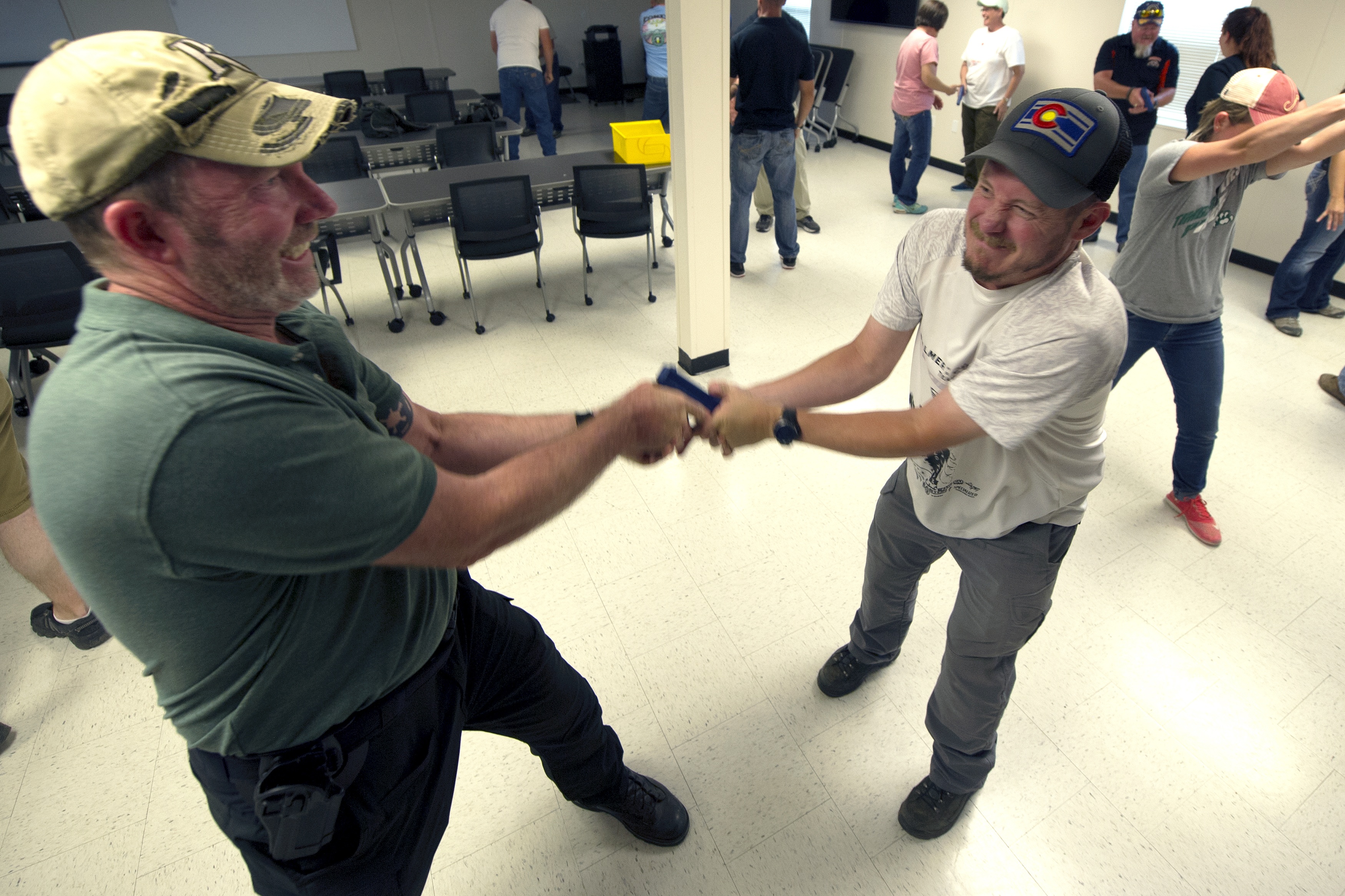 John Coppin (R), 52, a Facilities/ Safety and Security Director for a K-6 charter school practices gun retention techniques with John MacFarlane, a high school physics teacher during a three day firearms training course sponsored by FASTER Colorado at Flatrock Training Center in Commerce City, Colorado on June 28, 2018. (CREDIT: JASON CONNOLLY/AFP/Getty Images)