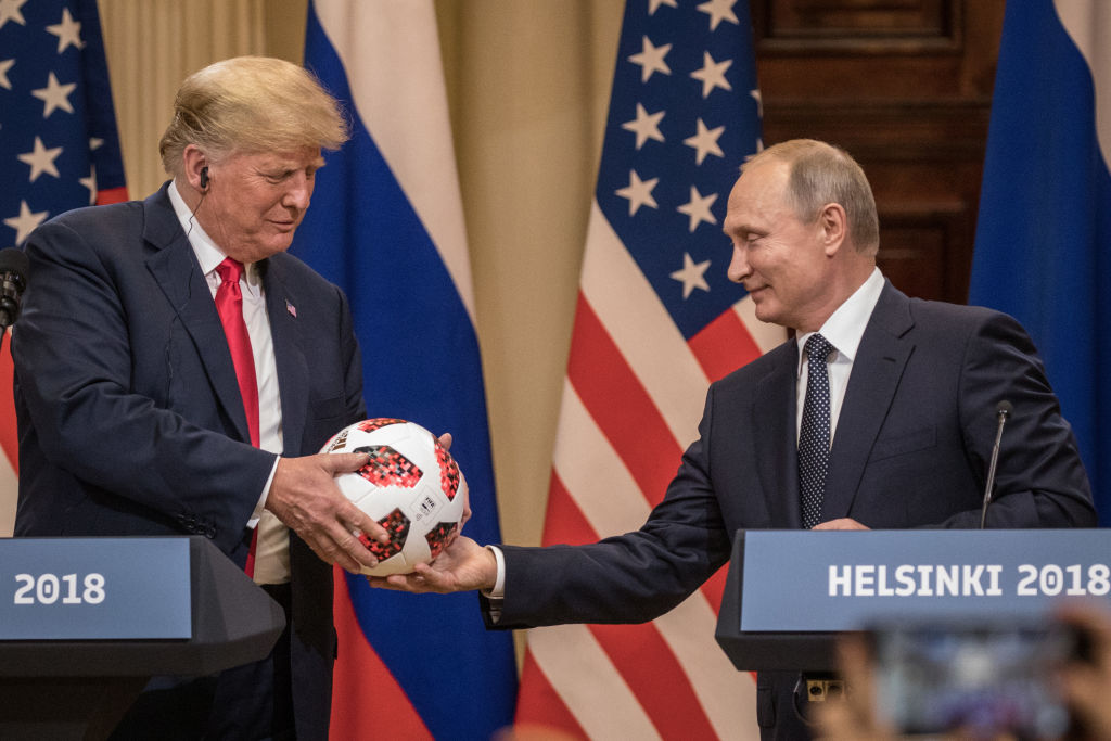 Russian President Vladimir Putin hands U.S. President Donald Trump a World Cup football during a joint press conference after their summit on July 16, 2018 in Helsinki, Finland. CREDIT: Chris McGrath/Getty Images