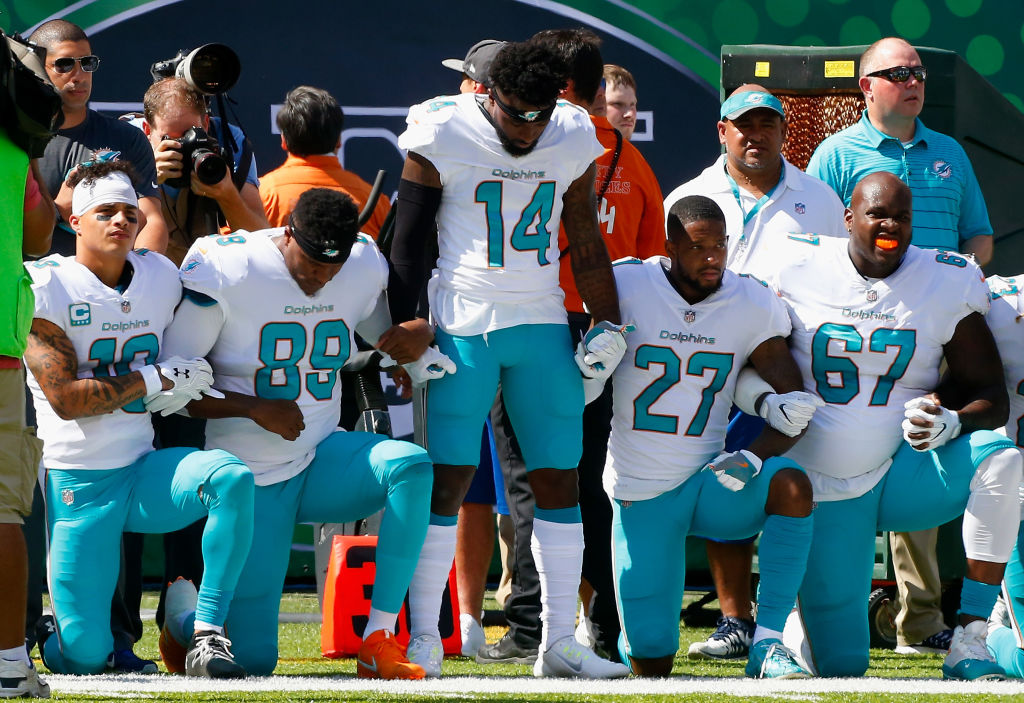 Miami Dolphins players protest police brutality against people of color during the national anthem before a game versus the New York Jets on September 24, 2017. (Jim McIsaac/Getty Images)
