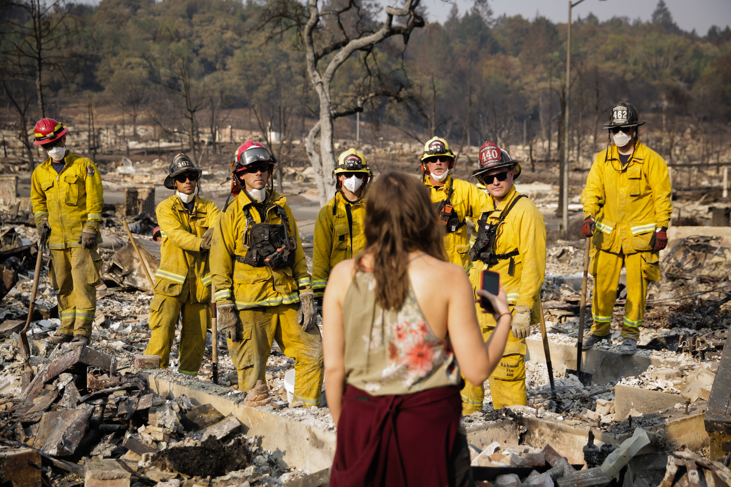 A survivor of the wine country wildfires in California speaks to firefighters as they search through the remains of a neighbor's home on October 13, 2017 in Santa Rosa, California. CREDIT: Elijah Nouvelage/Getty Images