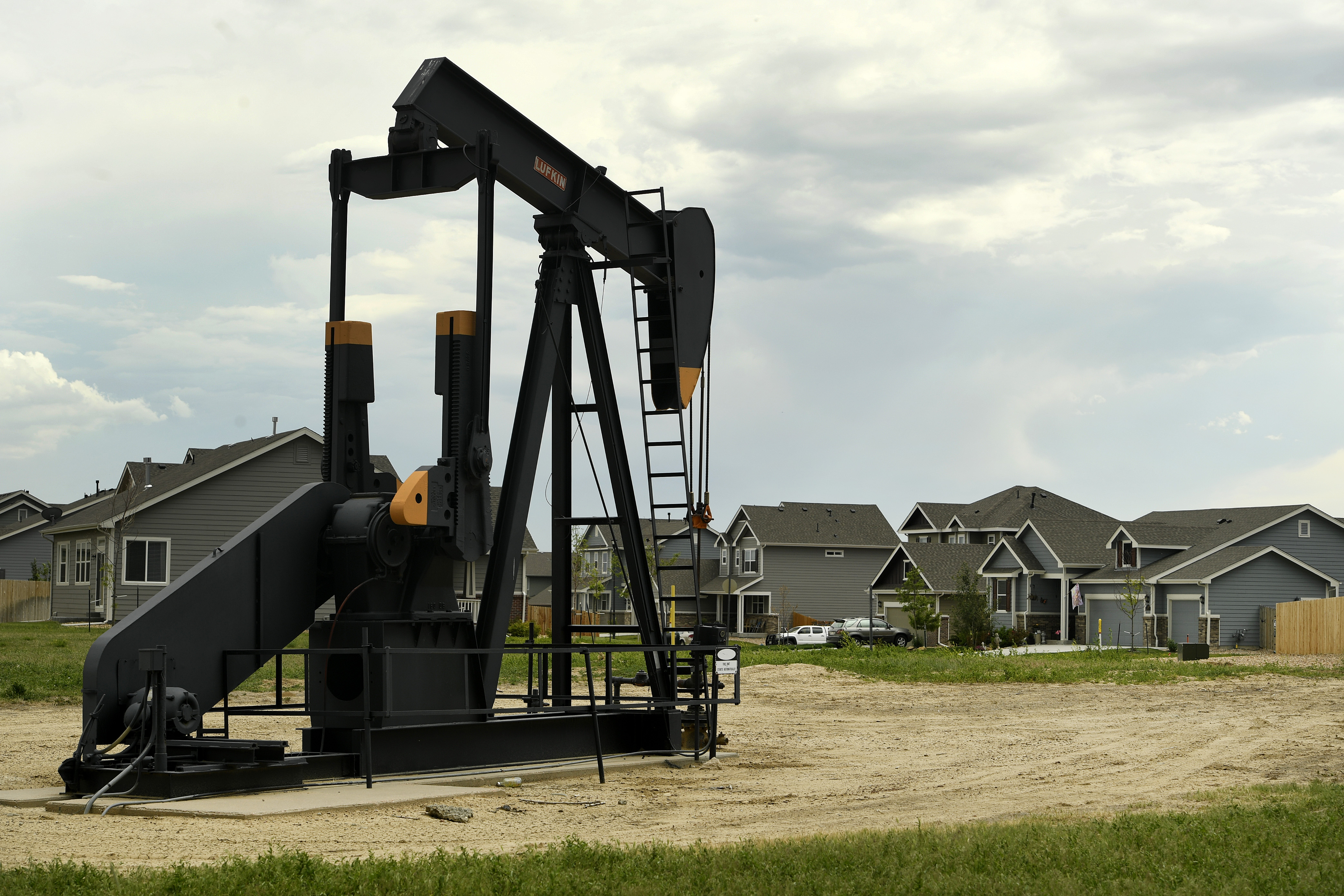 An oil derrick sits inside a housing development in Dacono, Colorado. CREDIT: Helen H. Richardson/The Denver Post via Getty Images