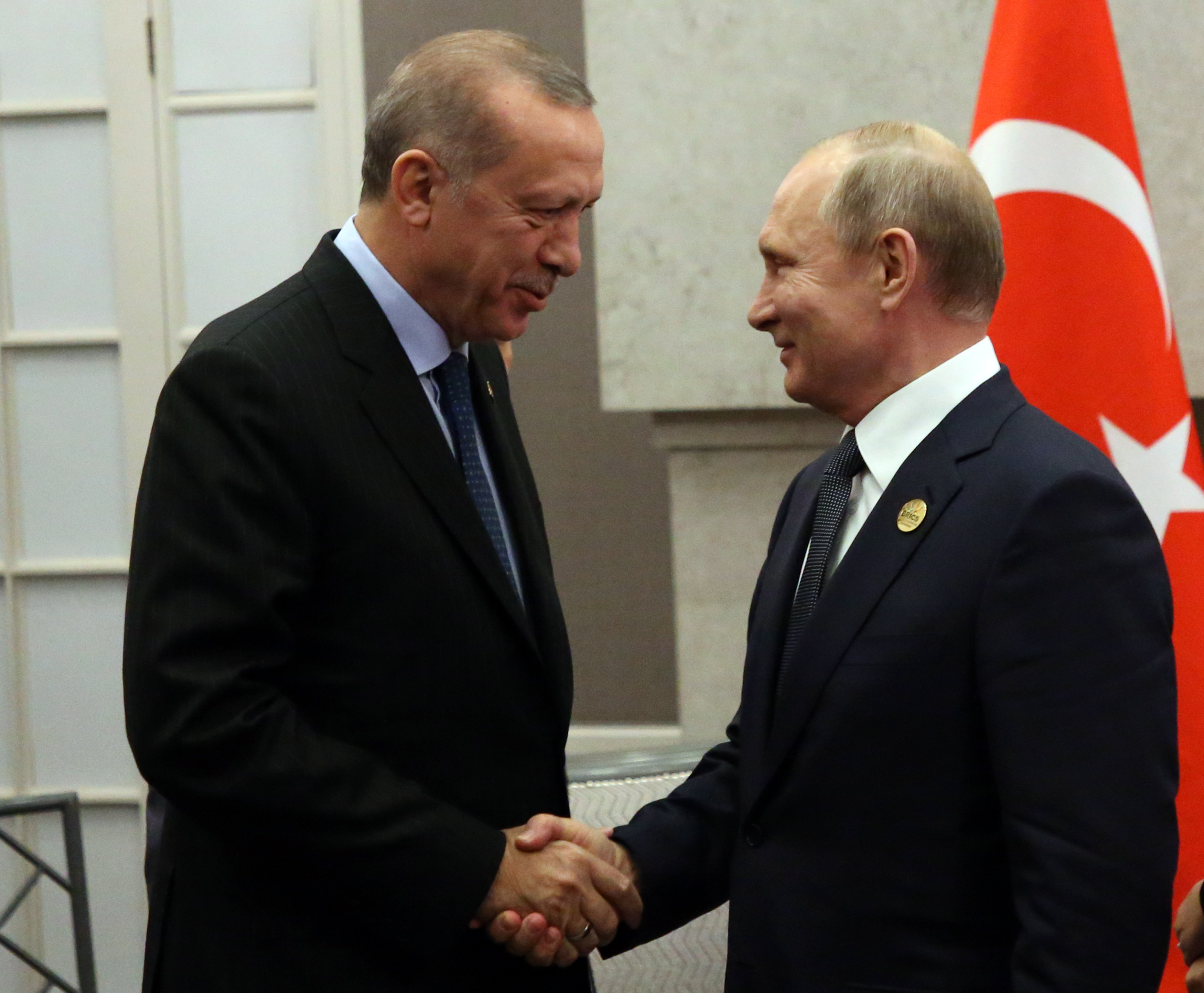 Russian President Vladimir Putin (greets Turkish President Recep Tayyip Erdogan during their meeting at the BRICS Summit in Johannesburg, South Africa, July 26, 2018. CREDIT: Mikhail Svetlov/Getty Images.
