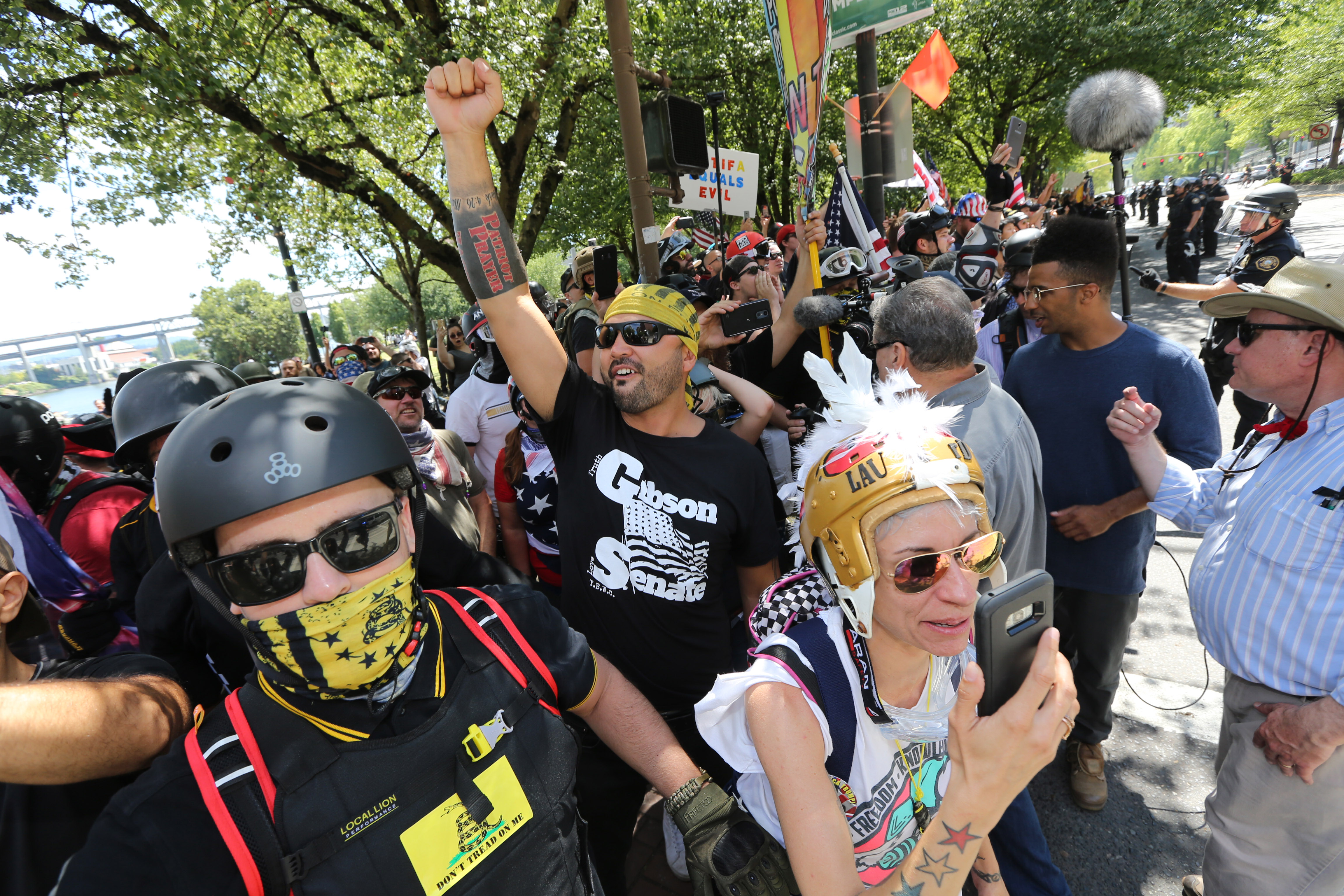 Rally organizer Joey Gibson (center) and right-wing demonstrators hold a rally supporting gun rights and free speech on August 4, 2018 in Portland, Oregon. The rally was organized by the group Patriot Prayer, also attended by the affiliated group Proud Boys, which drew counter protesters and members of the anti-fascist group Antifa. CREDIT: Karen Ducey/ Getty Images