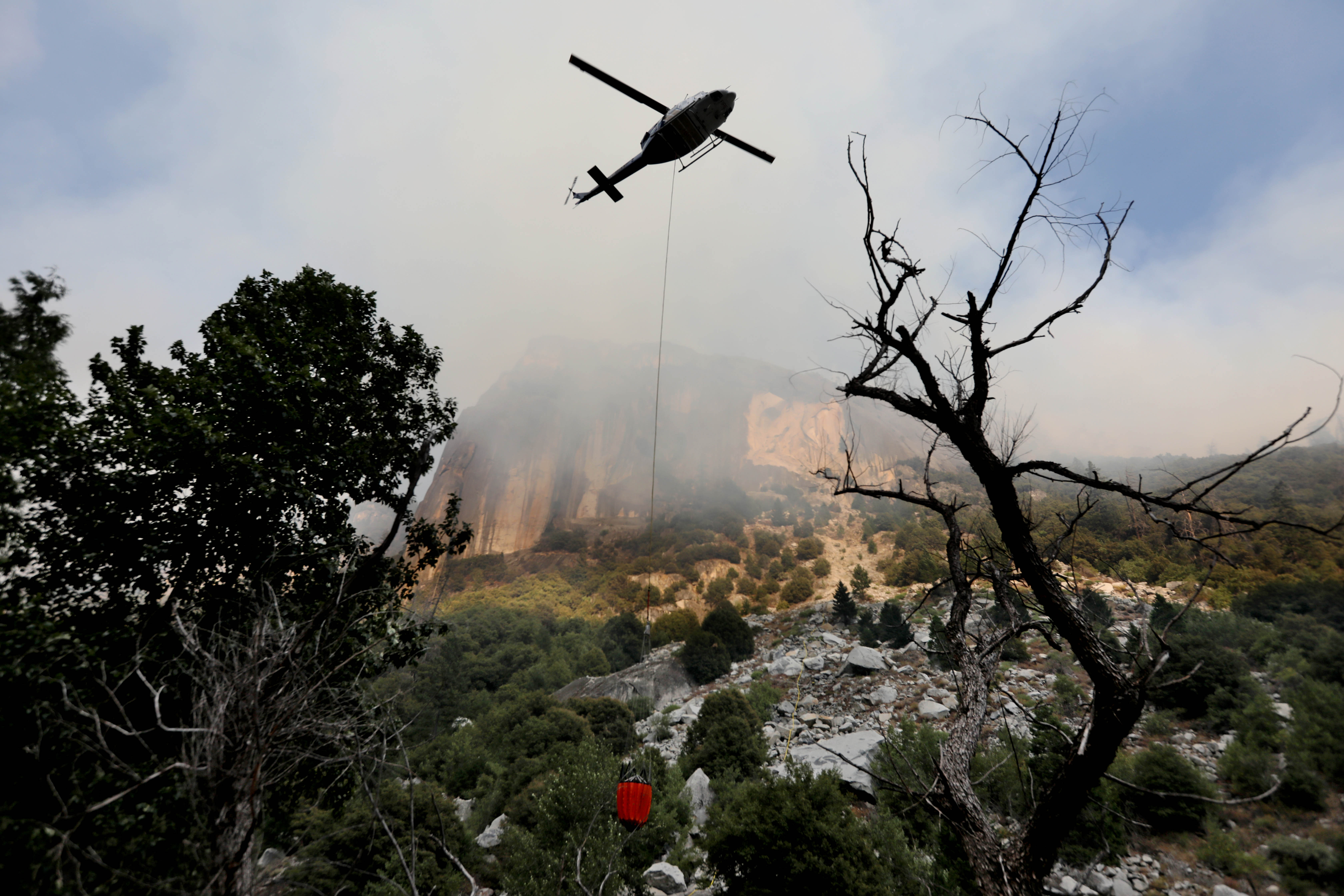 Helicopter crews work to stamp out the Ferguson fire as it burns along El Portal Road, a key entryway into Yosemite Valley, in Yosemite, Calif., on Aug. 13, 2018. CREDIT: Gary Coronado/Los Angeles Times via Getty Images