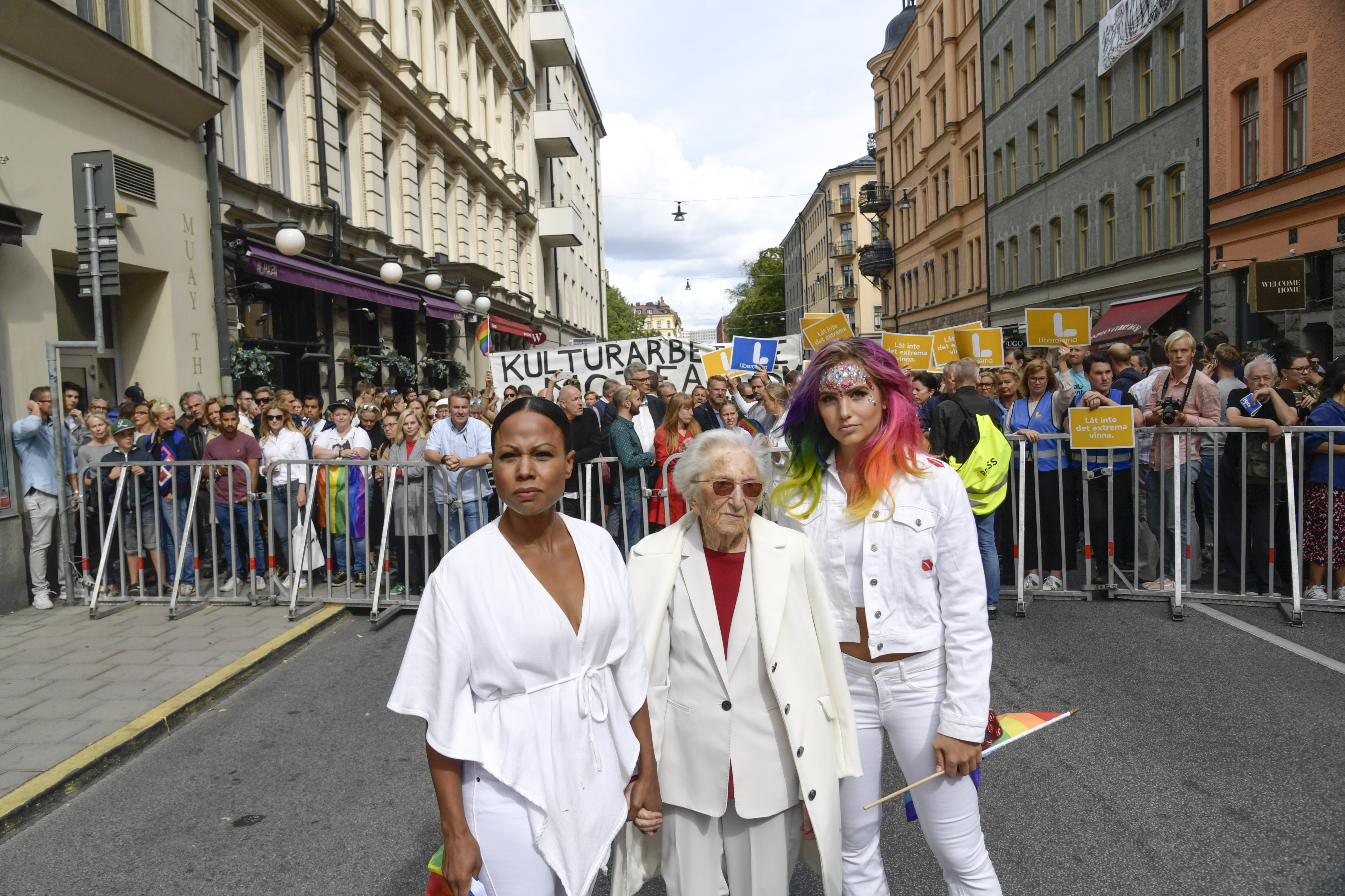 Swedish Culture minister Alice Bah Kuhnke, holocaust survivor Hedi Fried and handball player Linnea Claeson stand in front of the police barrier during a countermarch against a neo-Nazi Nordic Resistance Movement demonstration at the Kungsholmstorg square in Stockholm, Sweden on August 25, 2018. CREDIT: Pontus Lundahl/AFP/Getty Images.