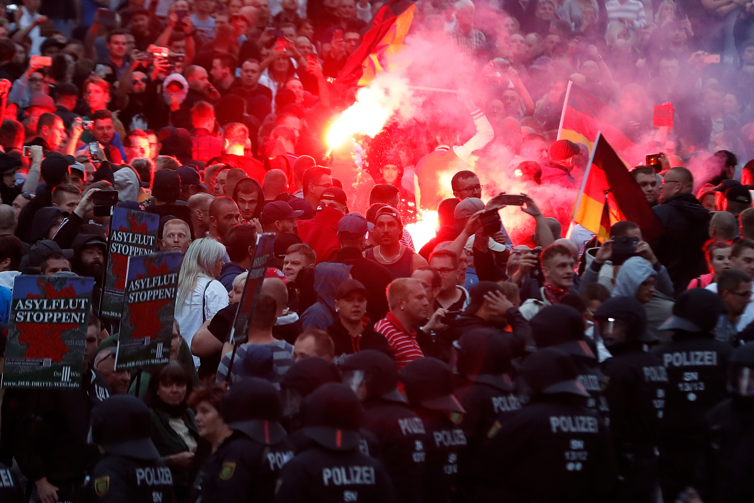 TOPSHOT - Right wing demonstrators light flares on August 27, 2018 in Chemnitz, eastern Germany, following the death of a 35-year-old German national who died in hospital after being stabbed. (Photo by Odd ANDERSEN / AFP) (Photo credit should read ODD ANDERSEN/AFP/Getty Images)