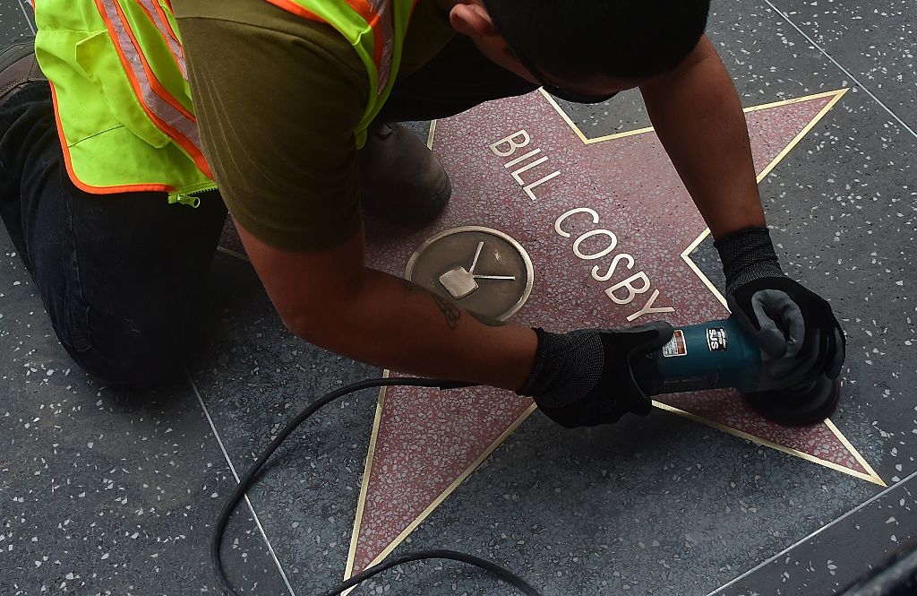 A worker cleans actor Bill Cosby's Star on the Hollywood Walk of Fame on December 5, 2014 in Hollywood, California after it was reportedly vandalized the night before with the word "rapist" written multiple times on the Star. CREDIT: FREDERIC J. BROWN/AFP/Getty Images