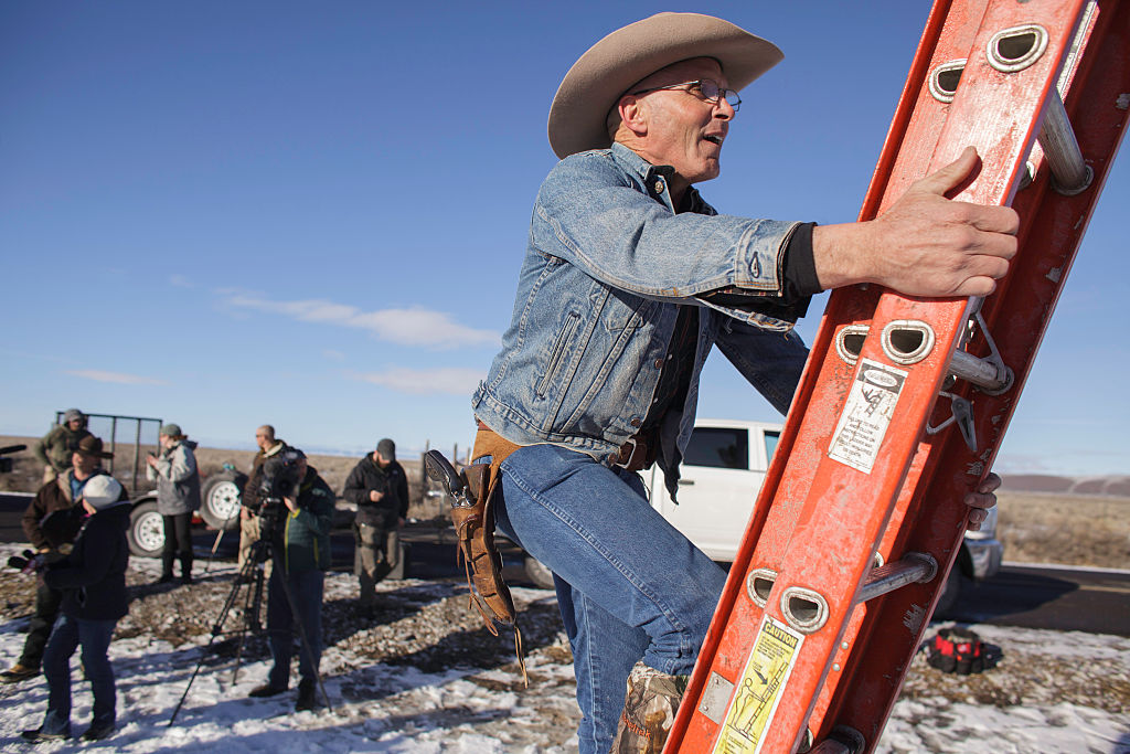 LaVoy Finicum, seen here disabling a wildlife camera during the armed occupation of the Malheur National Wildlife Refuge in 2016, was killed by police after running a roadblock during the standoff. An FBI agent present at the killing is now on trial. CREDIT: ROB KERR/AFP/Getty Images