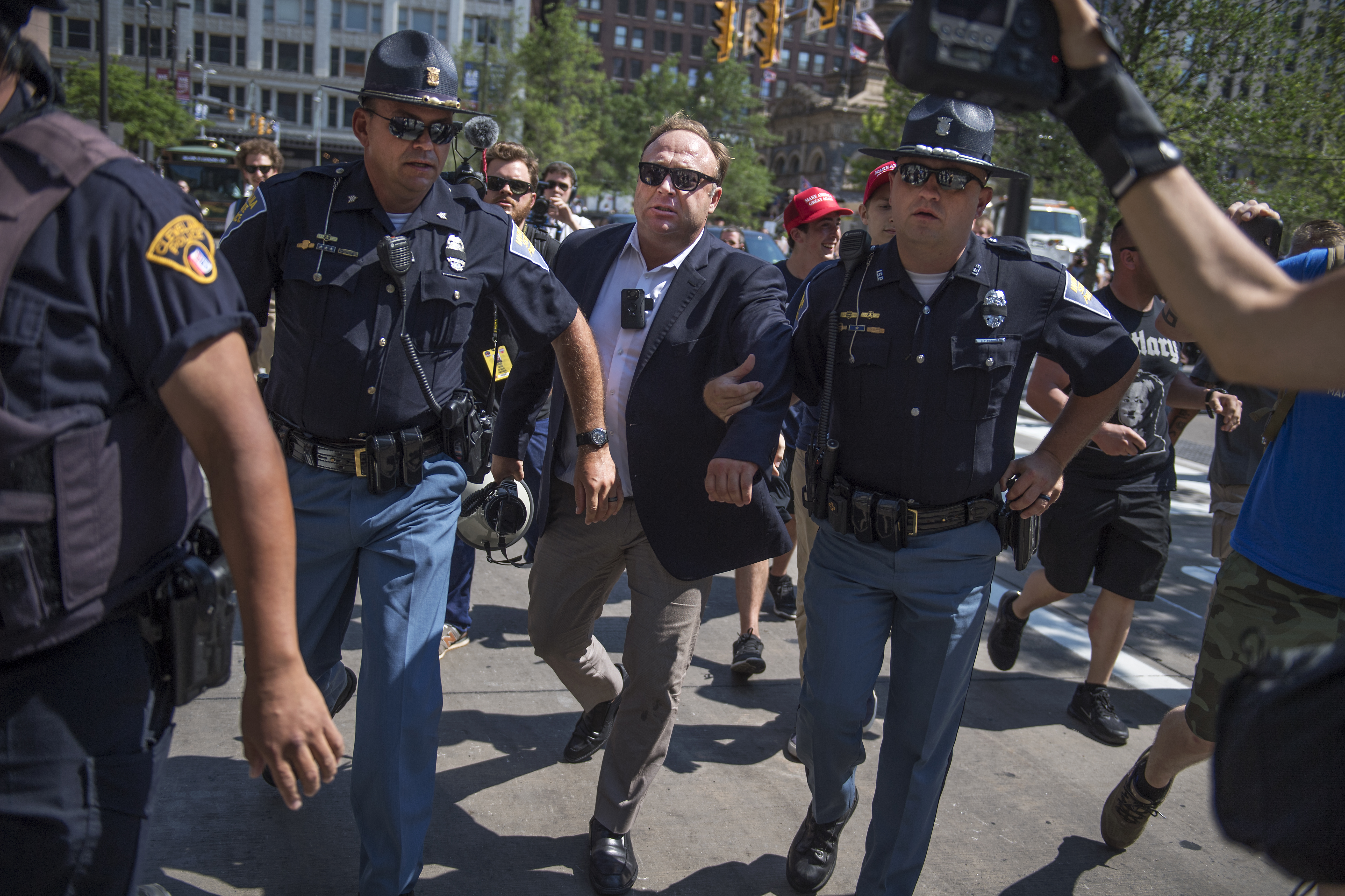 UNITED STATES - JULY 19: Radio host Alex Jones is escorted from a rally in the Public Square after inciting a confrontation near the Republican National Convention at the Quicken Loans Arena in Cleveland, Ohio, July 19, 2016. (Photo By Tom Williams/CQ Roll Call)