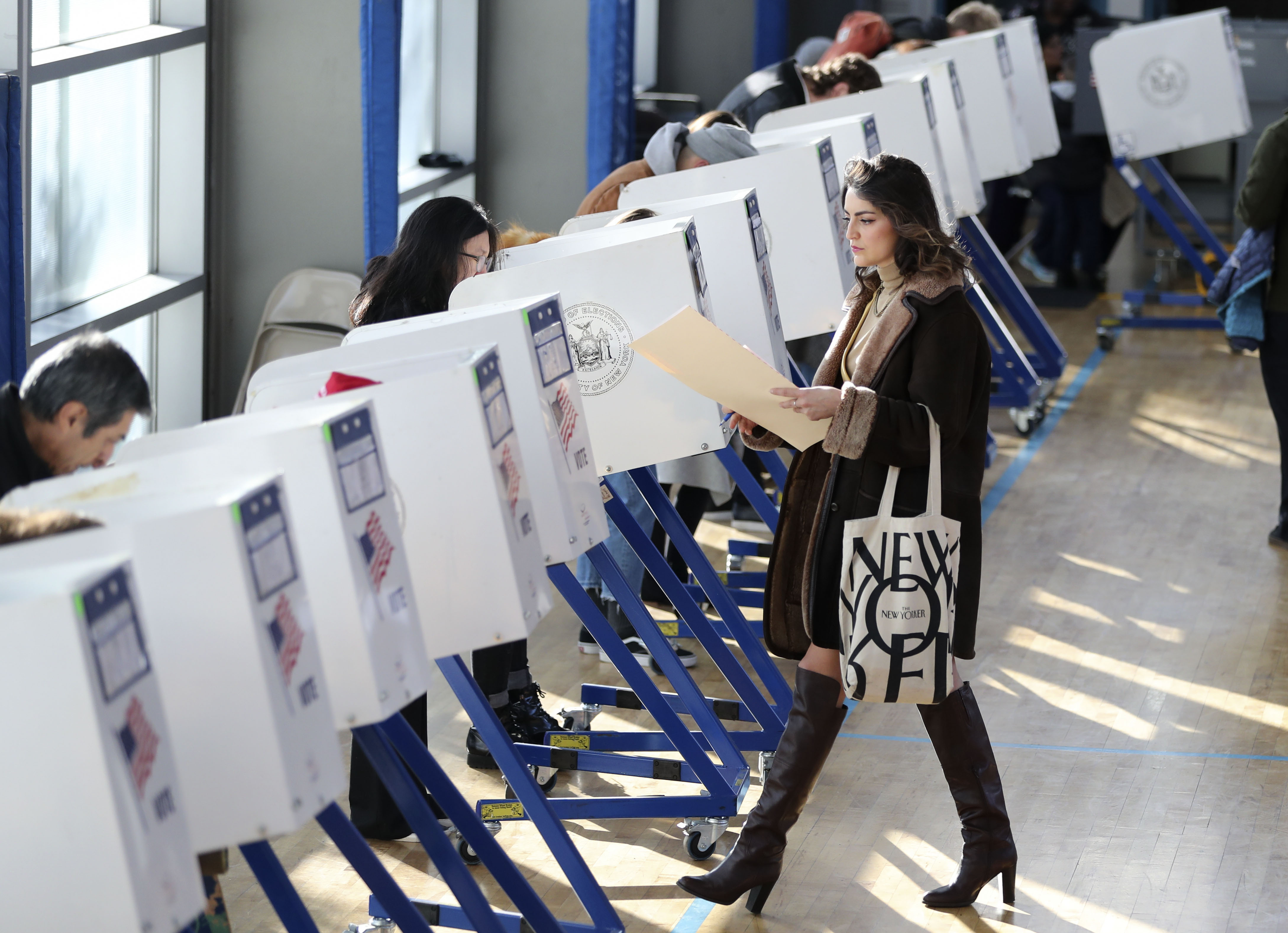 A voter walks to a booth to fill in her ballot at a polling station in Brooklyn, New York, the United States, on Nov. 8, 2016. CREDIT: Xinhua/Wang Ying via Getty Images