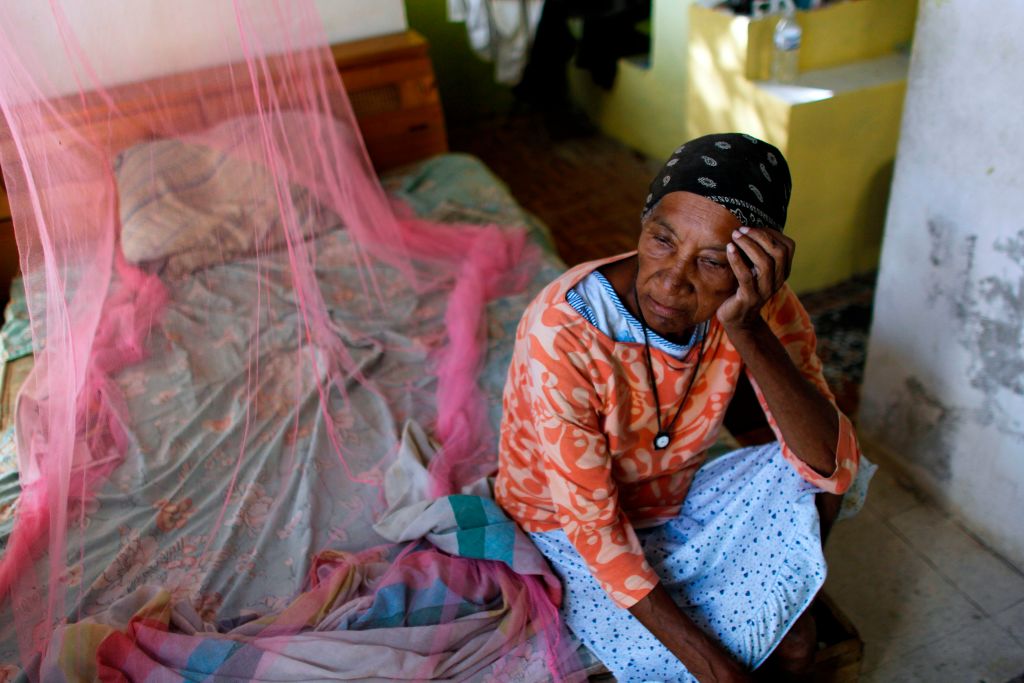 Aurea Cruz, 66, sits on her bed inside her house damaged by Hurricane Maria in Vieques, Puerto Rico on November 26, 2017. CREDIT: RICARDO ARDUENGO/AFP/Getty Images