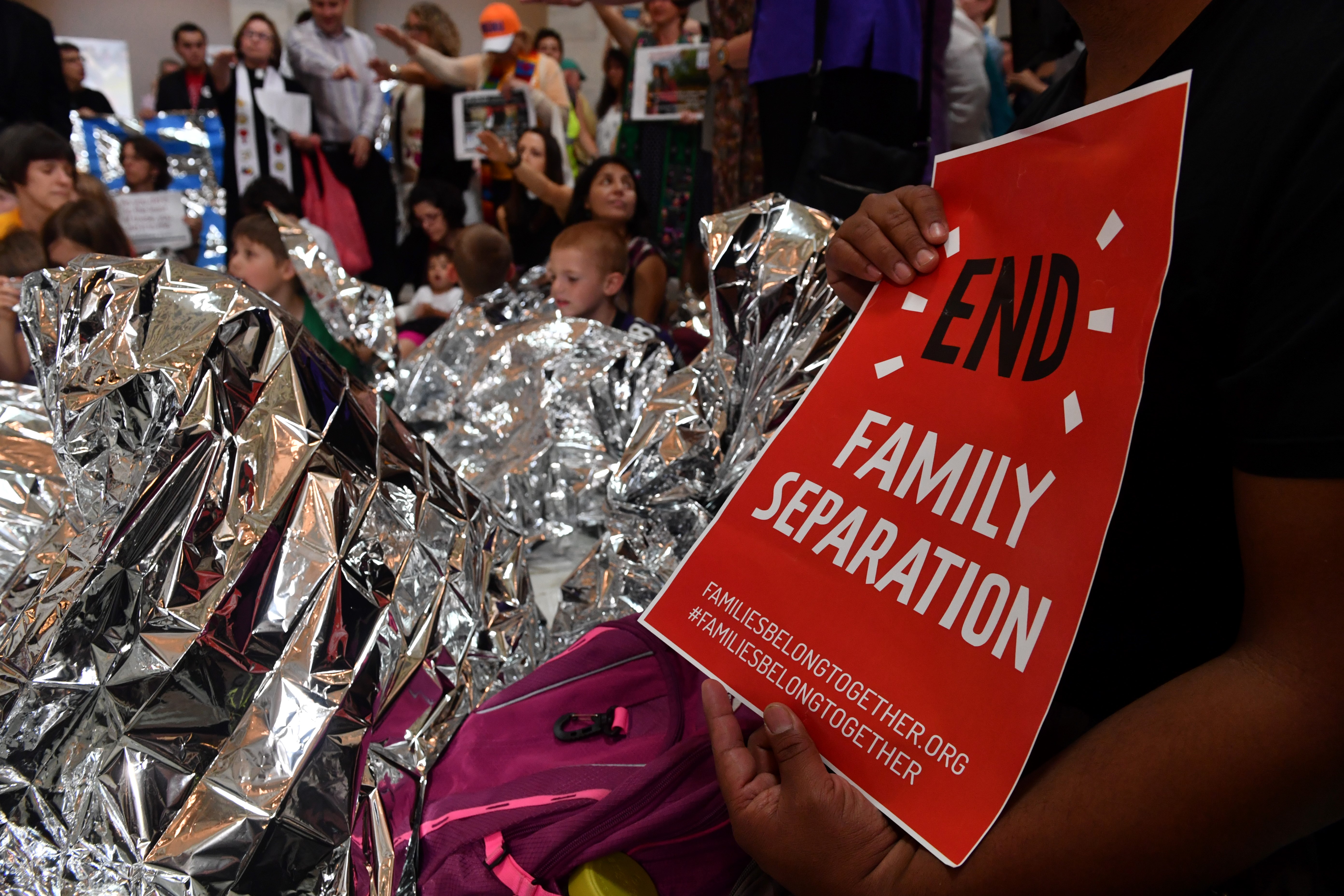 The Franciscan Action Network (FAN), Faith in Action and the DMV Congregation Network
holds a prayer vigil with children wrapped in survival blankets and protest "the cruel treatment of immigrants by the Trump administration" in the Russell Senate Office Building rotunda at the US Capitol on June 21, 2018 in Washington DC. - US lawmakers were poised to vote Thursday on long-term Republican-sponsored fixes to immigration amid a firestorm over family separations on the US-Mexico border. (Photo by Nicholas Kamm / AFP) (Photo credit should read NICHOLAS KAMM/AFP/Getty Images)