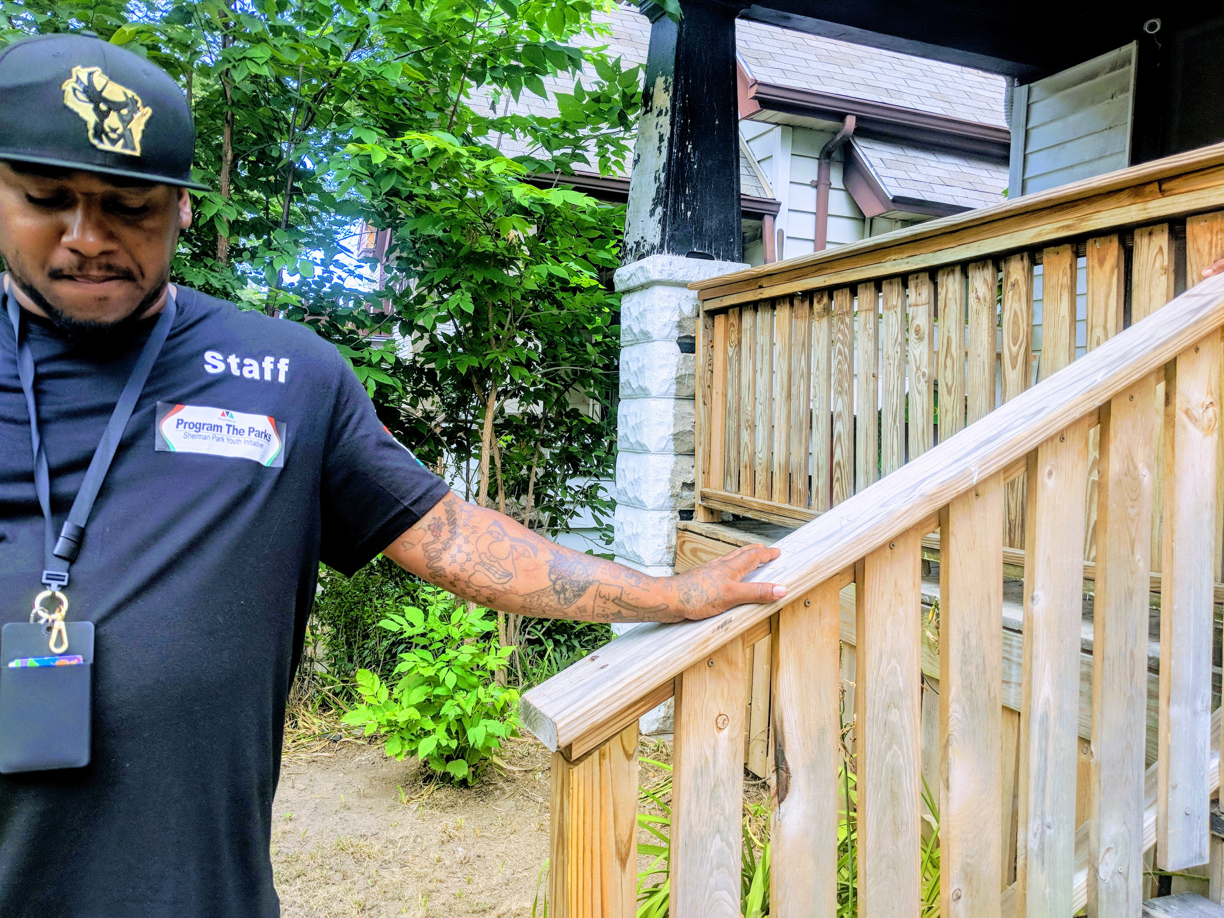 Vaun Mayes rests a hand on the newly-refurbished railing of the house that doubles as a community center for his Sherman Park non-profit, and his current home. CREDIT: Alan Pyke/ThinkProgress
