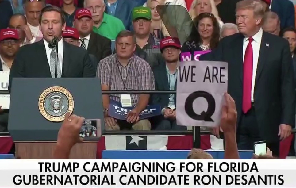 A QAnon supporter holds a sign at the Tampa Rally (Credit: Fox News, Screengrab)