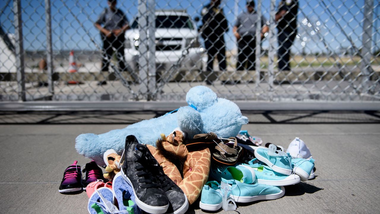 TOPSHOT - Security personal stand before shoes and toys left at the Tornillo Port of Entry where minors crossing the border without proper papers have been housed after being separated from adults, June 21, 2018 in Tornillo, Texas. (Photo by Brendan Smialowski / AFP)