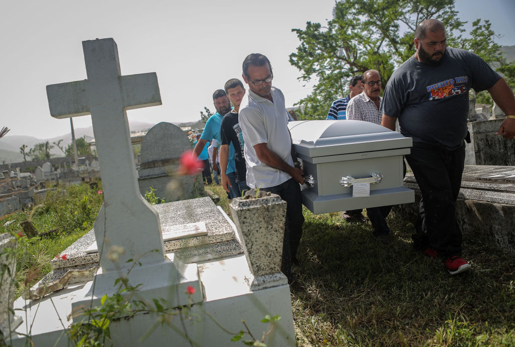 Mourners carry the casket of Wilfredo Torres Rivera, 58, who died October 13 after jumping off a bridge into a lake, three weeks after Hurricane Maria, on October 19, 2017 in Utuado, Puerto Rico. Utuado was one of the hardest hit areas on the island. (Credit: Mario Tama/Getty Images)