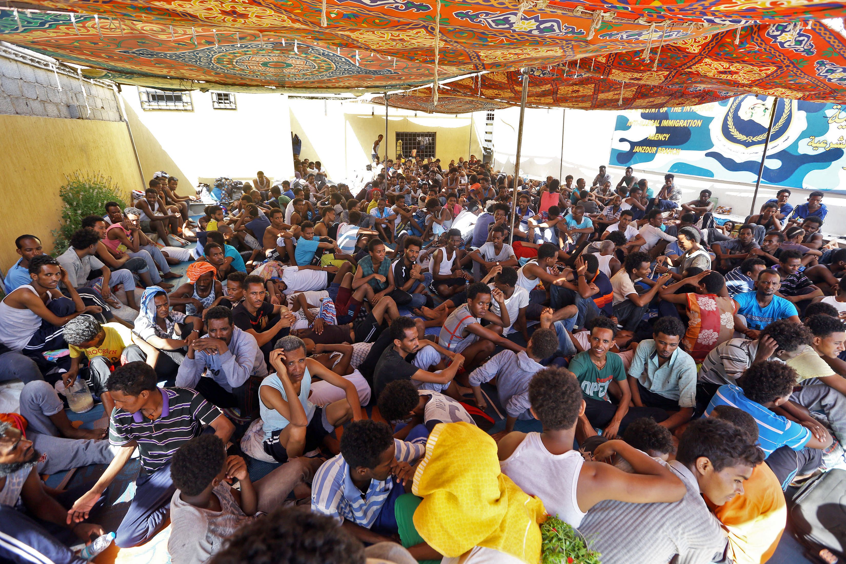Migrants sit inside the Ganzour shelter after being transferred from in the airport road due to fighting in the Libyan capital Tripoli on September 5, 2018. CREDIT: Mahmud TurkiaI/AFP/Getty Images.