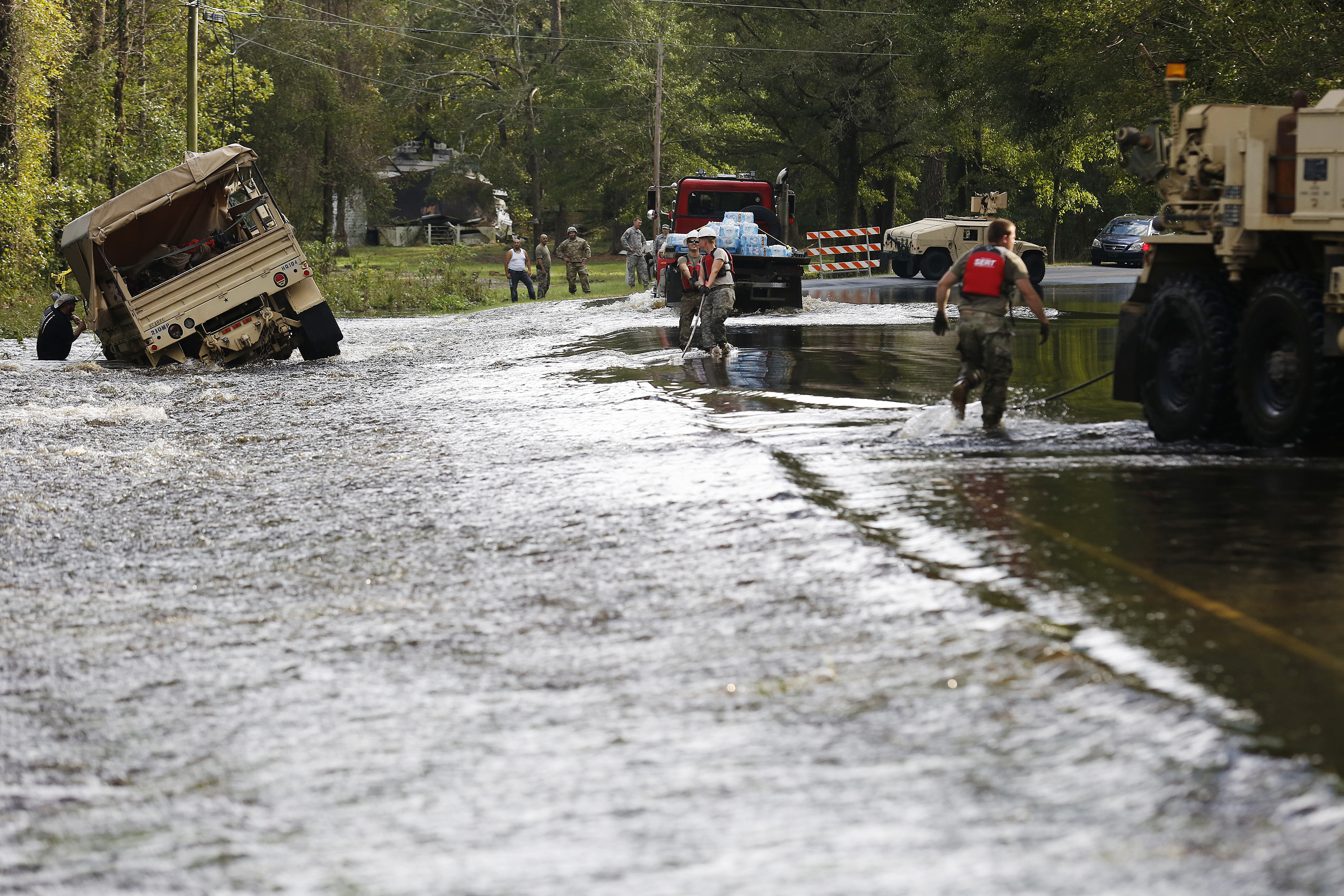 Troops work to pull a truck out of flood waters that washed away on Chicken Road outside of Lumberton, North Carolina, Monday, September 17, 2018. CREDIT: Eamon Queeney/For The Washington Post via Getty Images