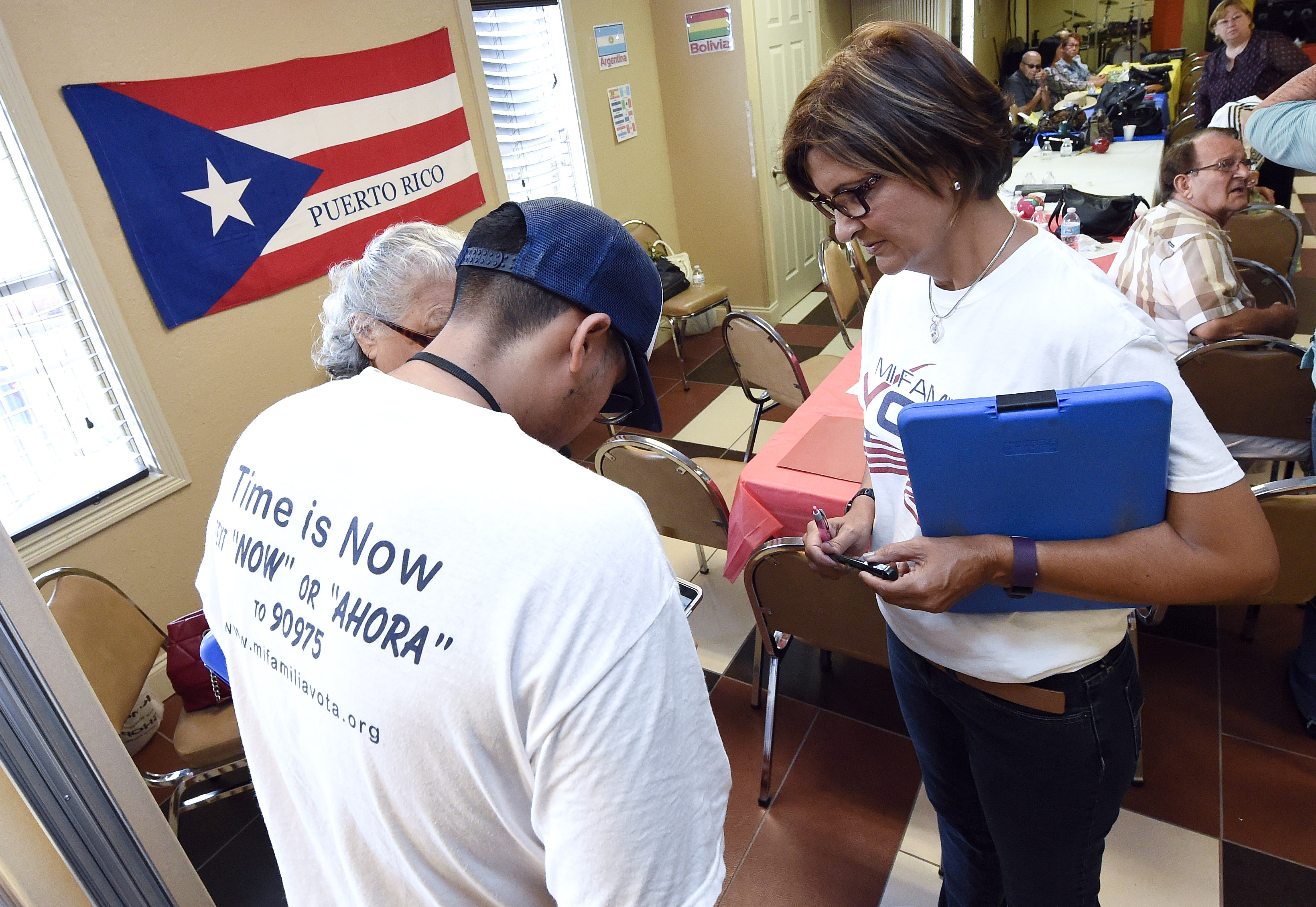 "Mi Famila Vota" (My Family Votes) representative Jose Castellanos (L) and Naloy Zapata (R) register people to vote during a Hispanic Heritage Celebration breakfast at the Kingdom of God Church in Orlando, Florida on October 4, 2016.
A group of volunteers registering Hispanic voters gets down to business at an apartment complex in the center of Florida, one of the key battleground states in the White House race. The bad news for Republicans is that most of those waiting to sign up before Tuesday's deadline are Puerto Ricans.
/ AFP / RHONA WISE (Photo credit should read RHONA WISE/AFP/Getty Images)