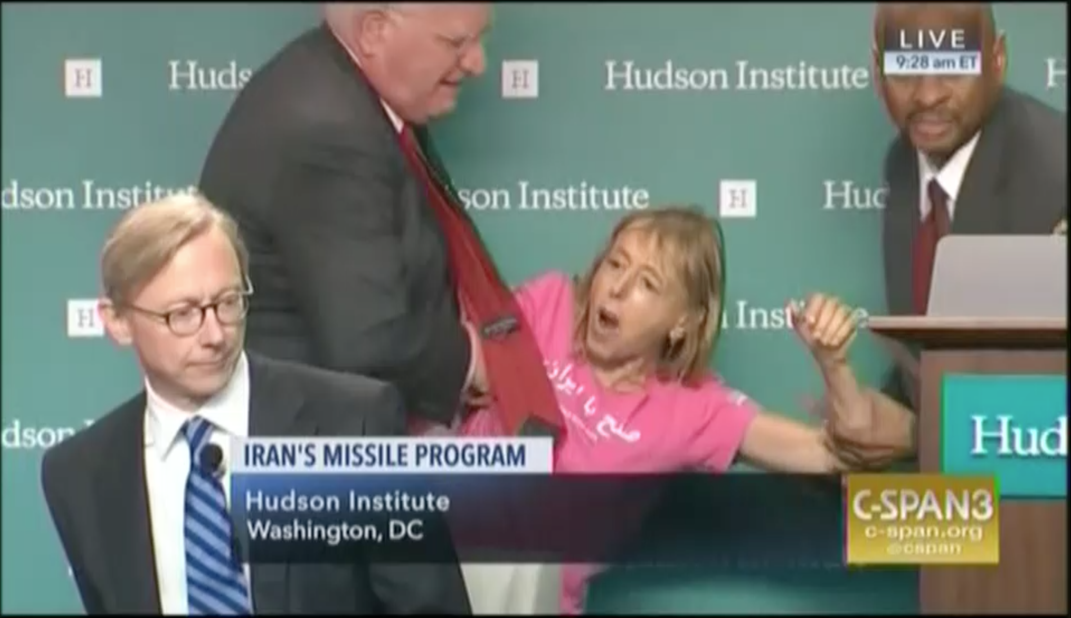 Medea Benjamin is carried off by two men at she peppers Iran Action Group leader Brian Hook with questions he does't want to hear. CREDIT: Screengrab, C-SPAN3