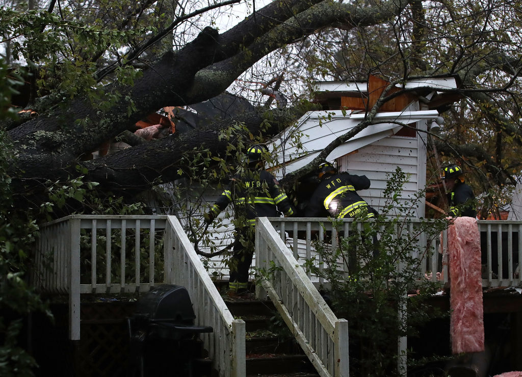 Firefighters look into a home that a large tree fell on during Hurricane Florence in Wilmington, North Carolina on September 14, 2018. (Mark Wilson/Getty Images)