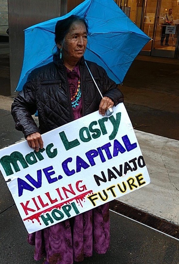 Protester stands outside Marc Lasry's offices in New York City to oppose proposed acquisition of coal-burning Navajo Generating Station. CREDIT: Tó Nizhóní Ání