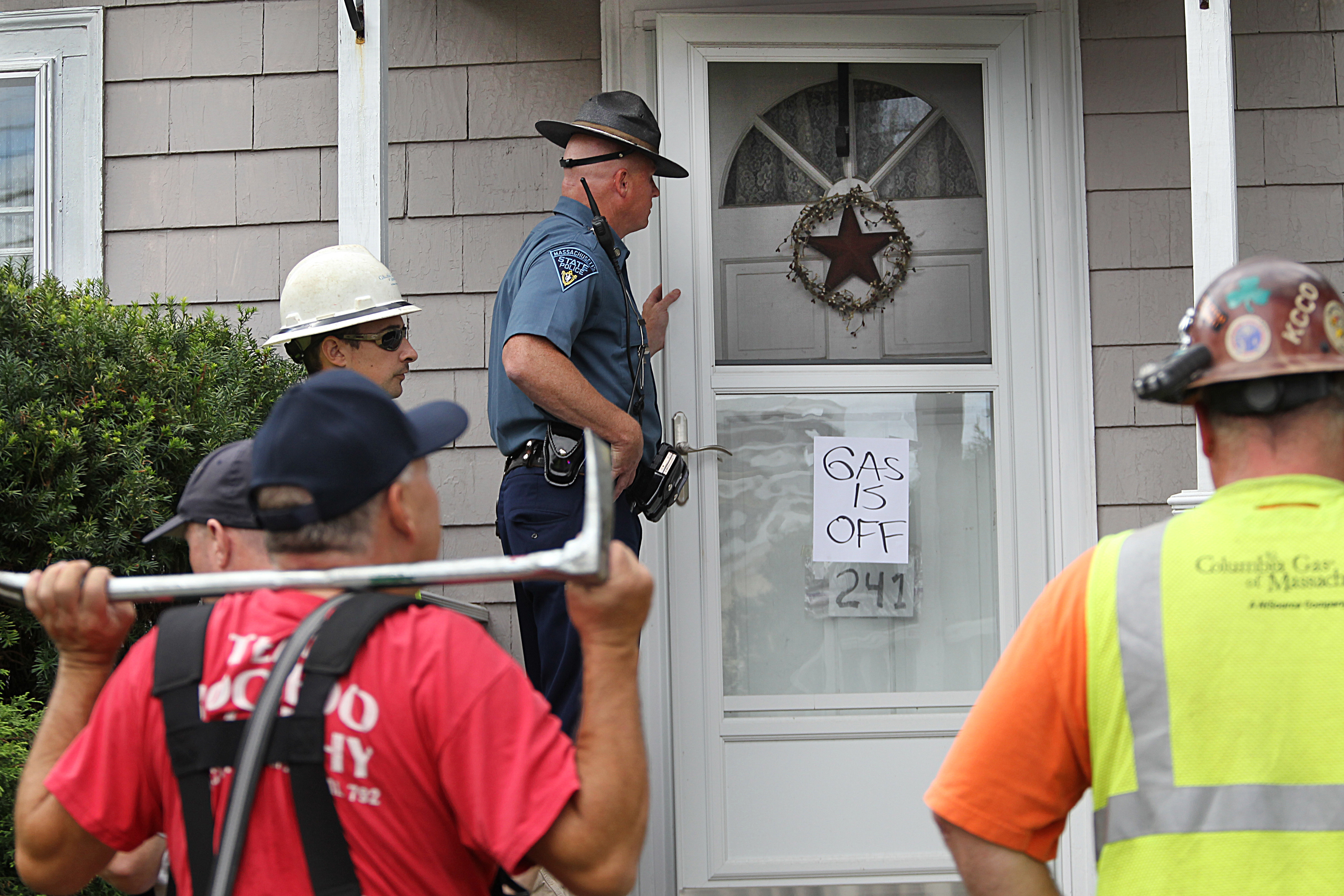 Firefighters, police officers, and Columbia Gas workers go house by house in North Andover on September 14, 2018, Massachusetts. CREDIT: Suzanne Kreiter/The Boston Globe via Getty Images