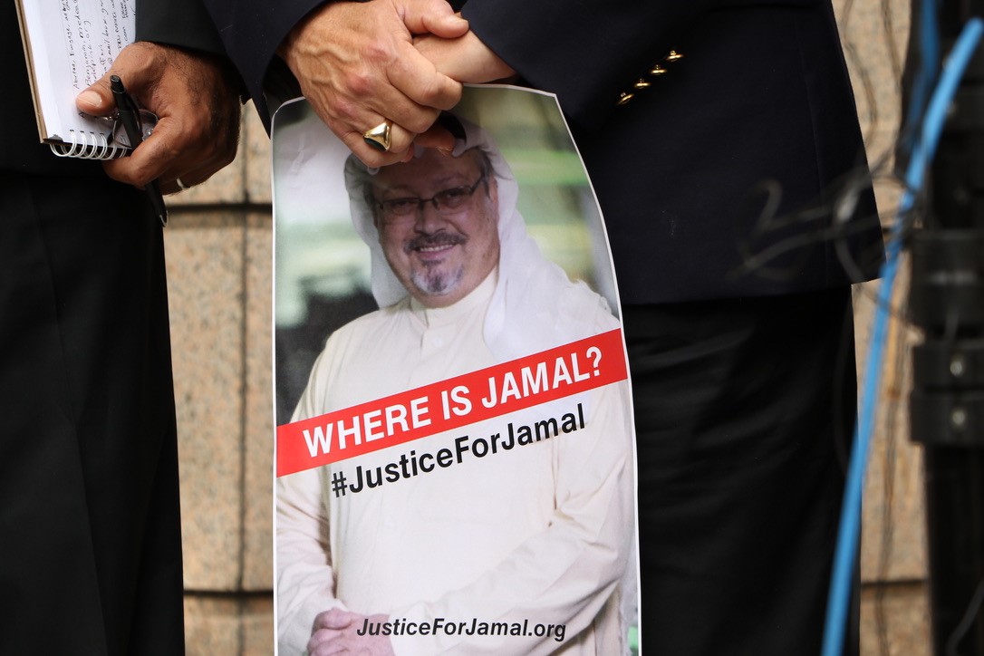 WASHINGTON, USA - OCTOBER 10: A member of the Organization 'Justice for Jamal Khashoggi' holds a picture of Khashoggi as he and other members hold news conference for disappearance of Saudi journalist in front of The Washington Post headquarters in Washington D.C. (Photo by Umar Farooq/Anadolu Agency/Getty Images)