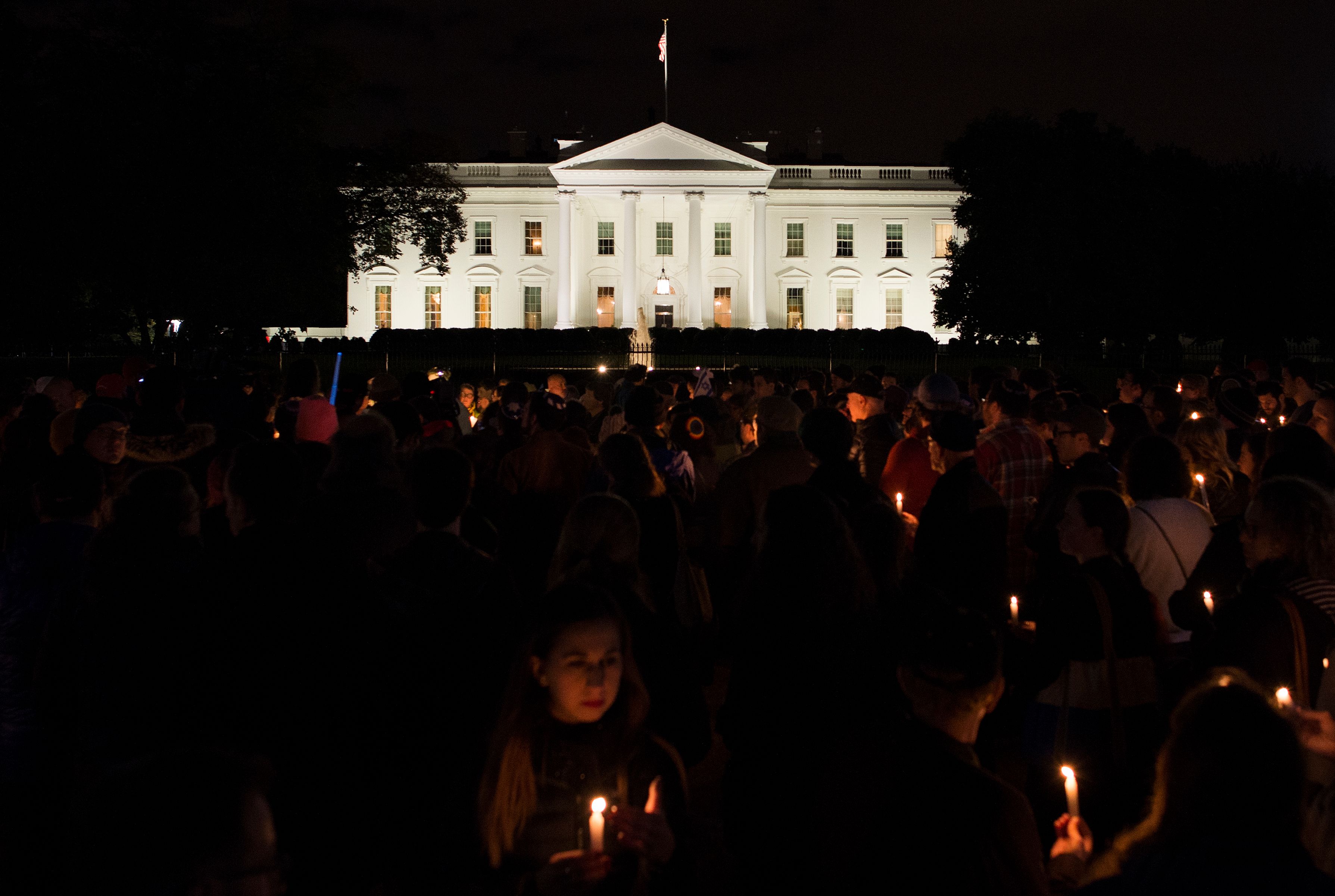 An open letter to President Trump, declaring that he is unwelcome in the city of Pittsburgh until he denounces white nationalism and reverses his policies targeting minorities and immigrants, was read at a vigil Sunday night in front of the White House. (PHOTO CREDIT: ANDREW CABALLERO-REYNOLDS/AFP/Getty Images)